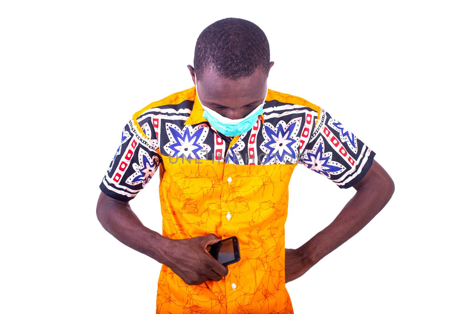 handsome young man wearing medical mask, sad holding cellphone and looking down.