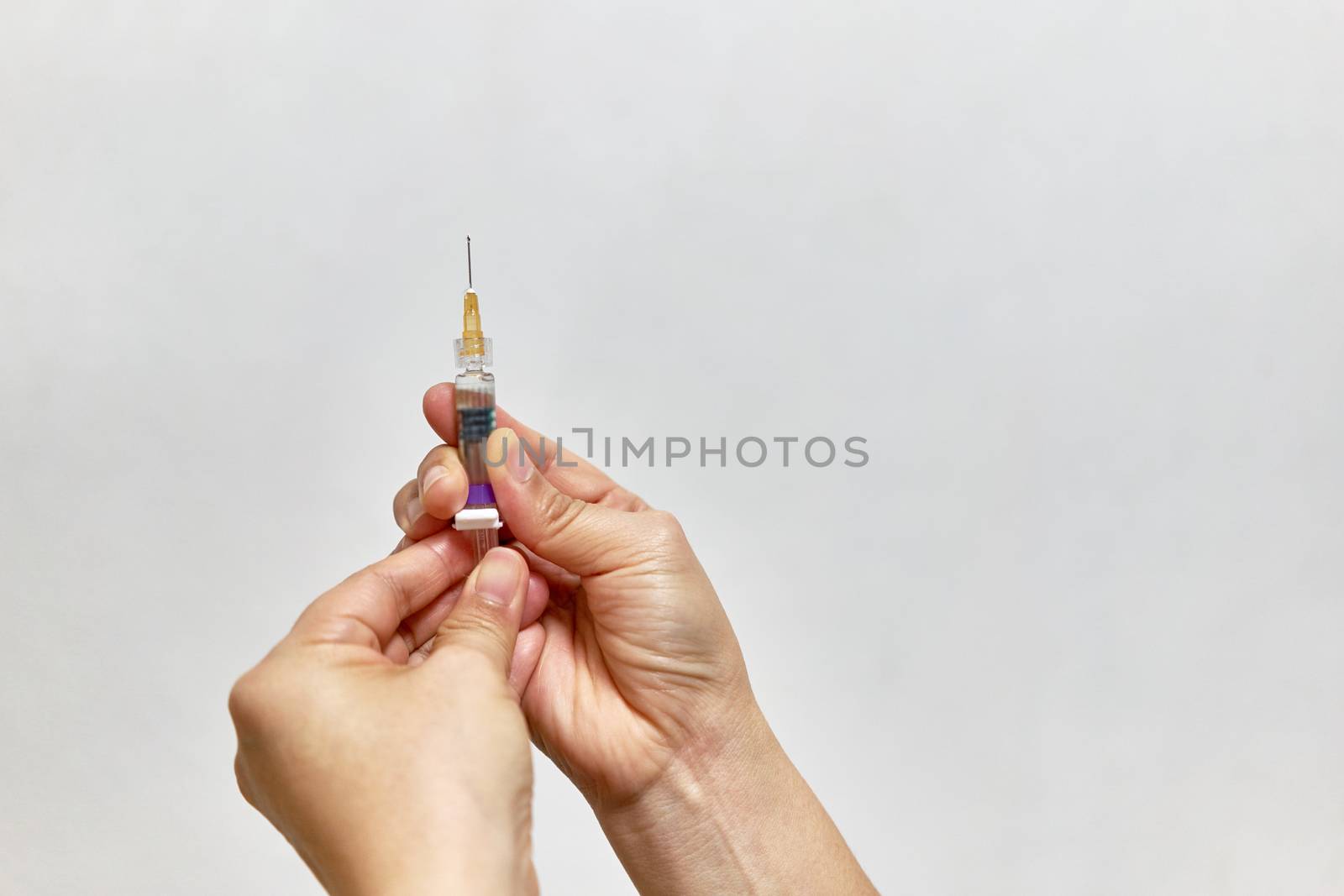 Hand of nurse holding hypodermic syringe vaccine of flu with white background and copy space.