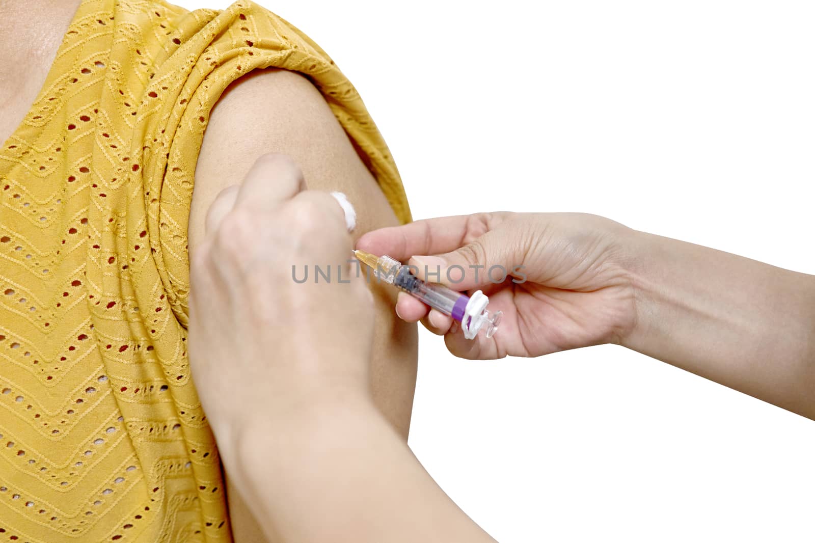 Hand of nurse pull hypodermic syringe injected vaccine of flu with cotton ball from left shoulder of woman in brown blouse isolated on white background. Healthcare and medical concept photography.