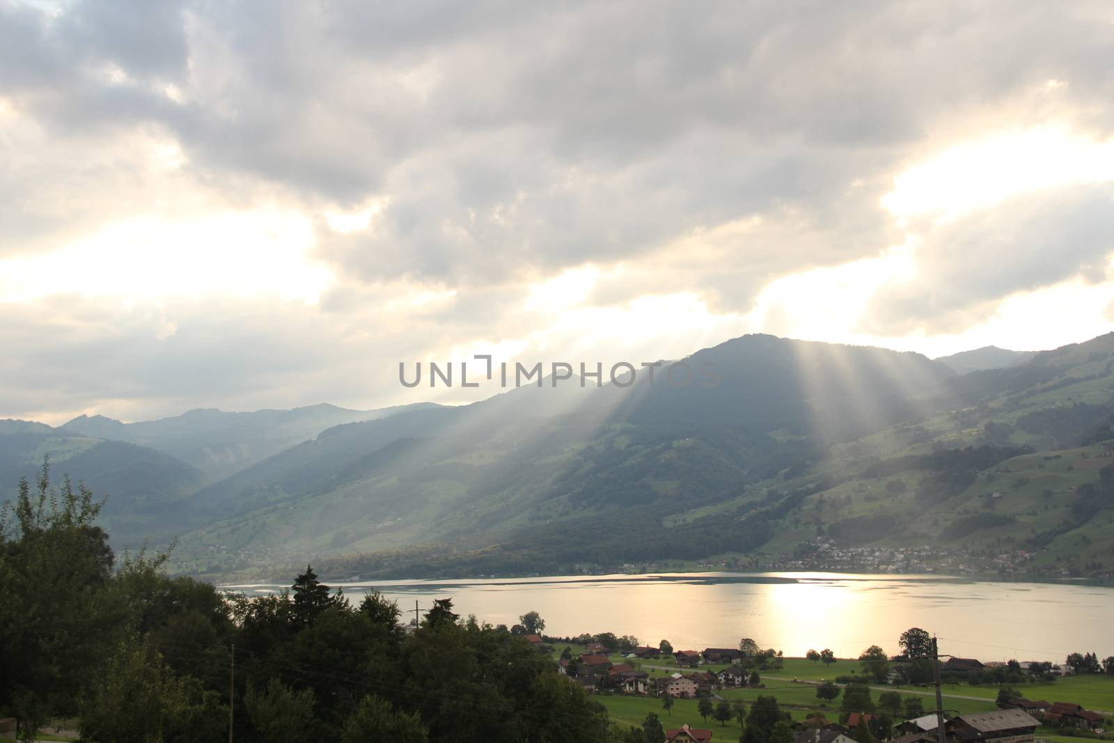 sunset in the mountains. With lake Sarnen, Switzerland. With sun rays and reflection