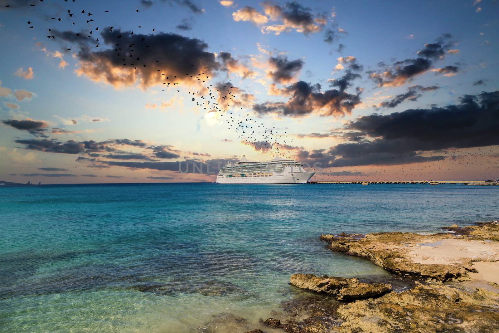 White Cruise Ship Past Rocky Shore at Sunset by dbvirago