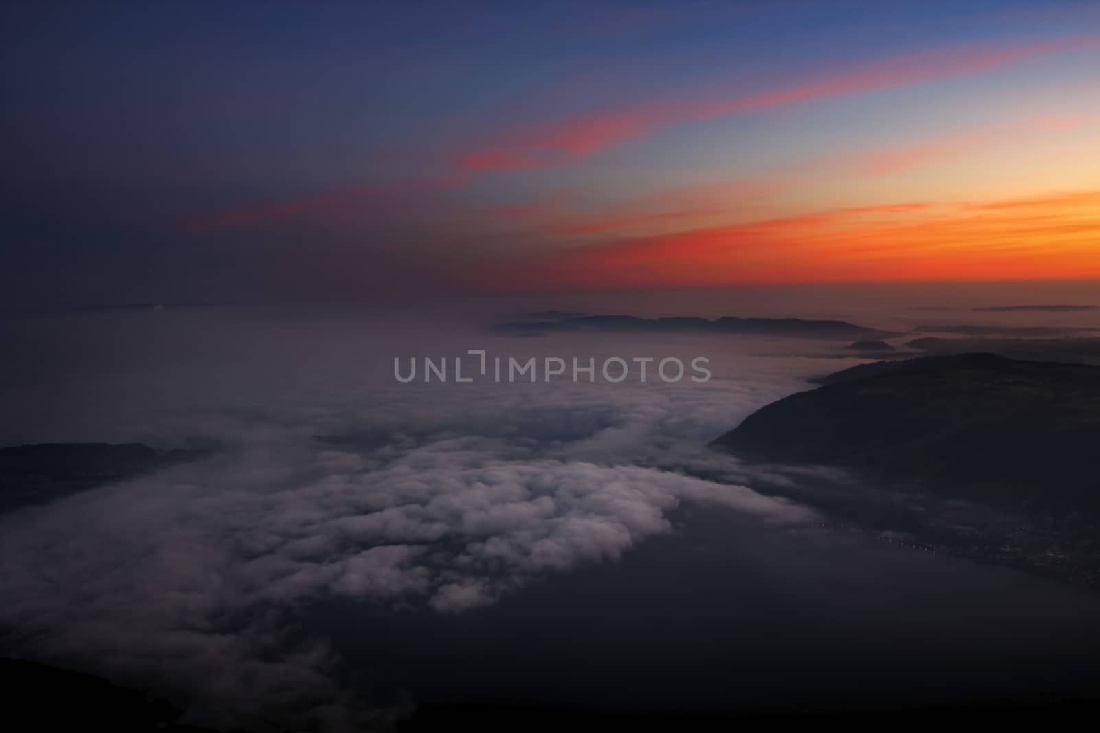 fog in the valley during sunrise. Photo taken from mount Rigi with red glowing sky