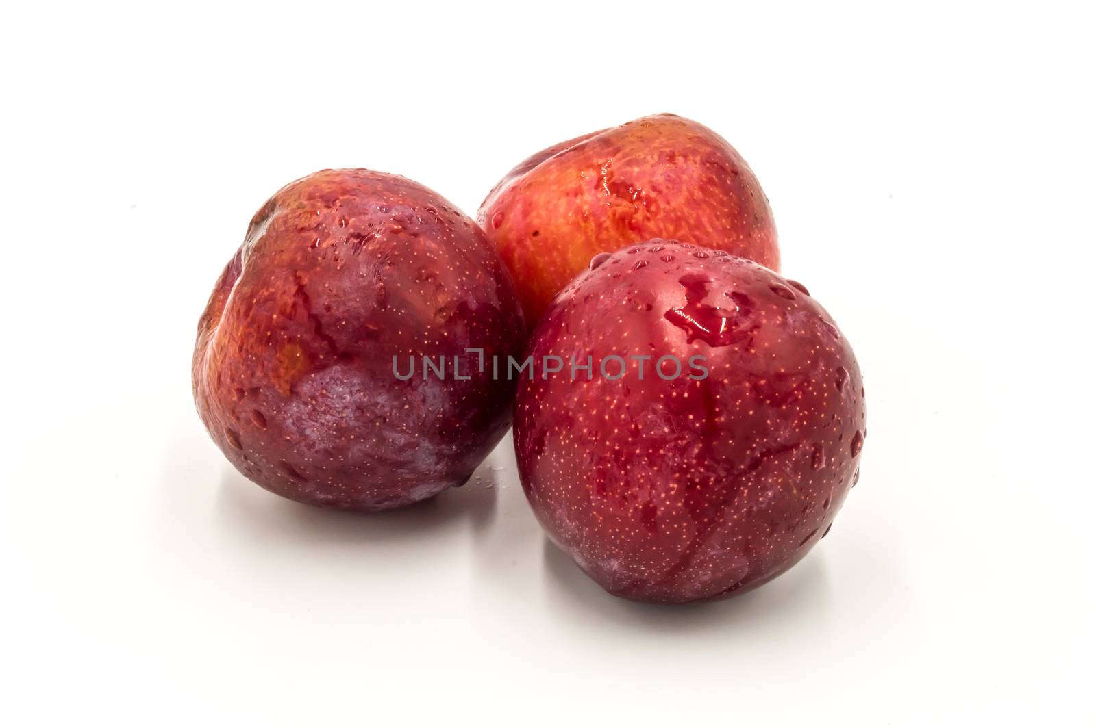 Three ripe red round plums isolated  by Philou1000