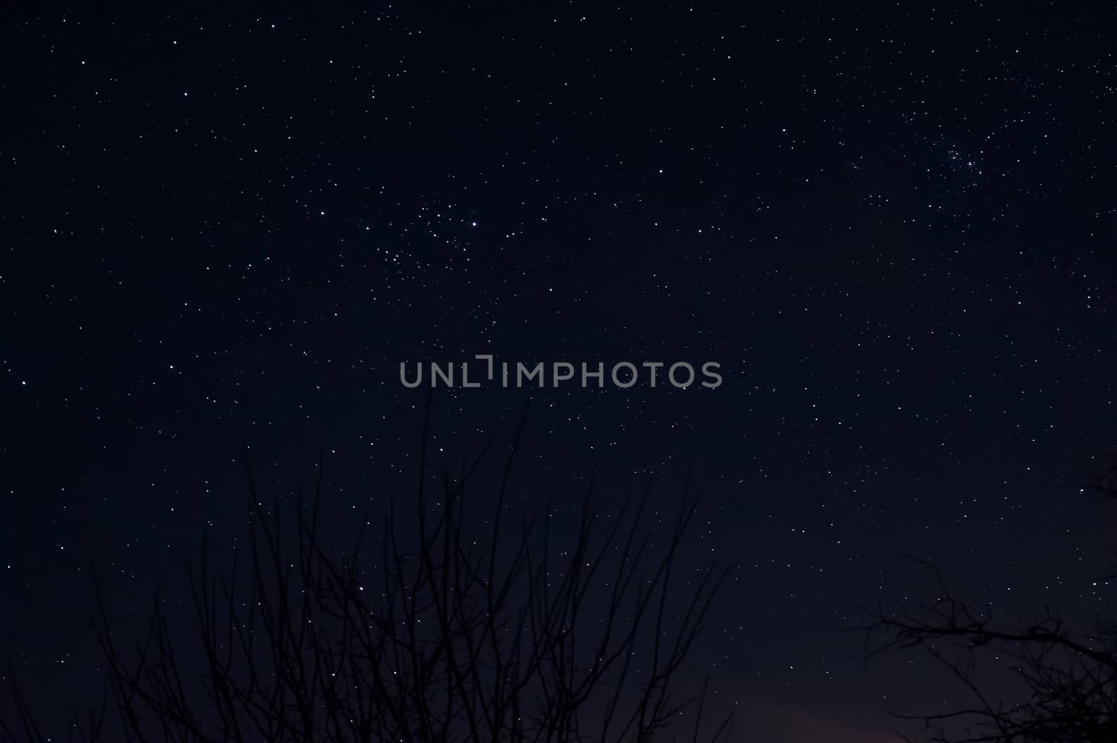 Long exposure night photo of a bright stars. A lot of stars with constellations. Far from the city. Night landscape.