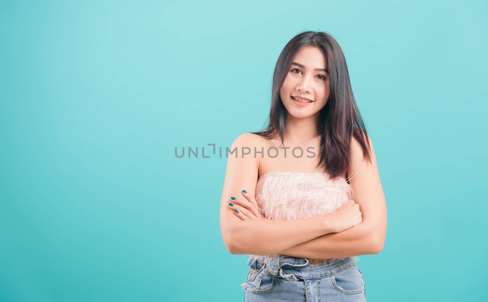 woman standing smiling white teeth her keeping arms crossed by Sorapop