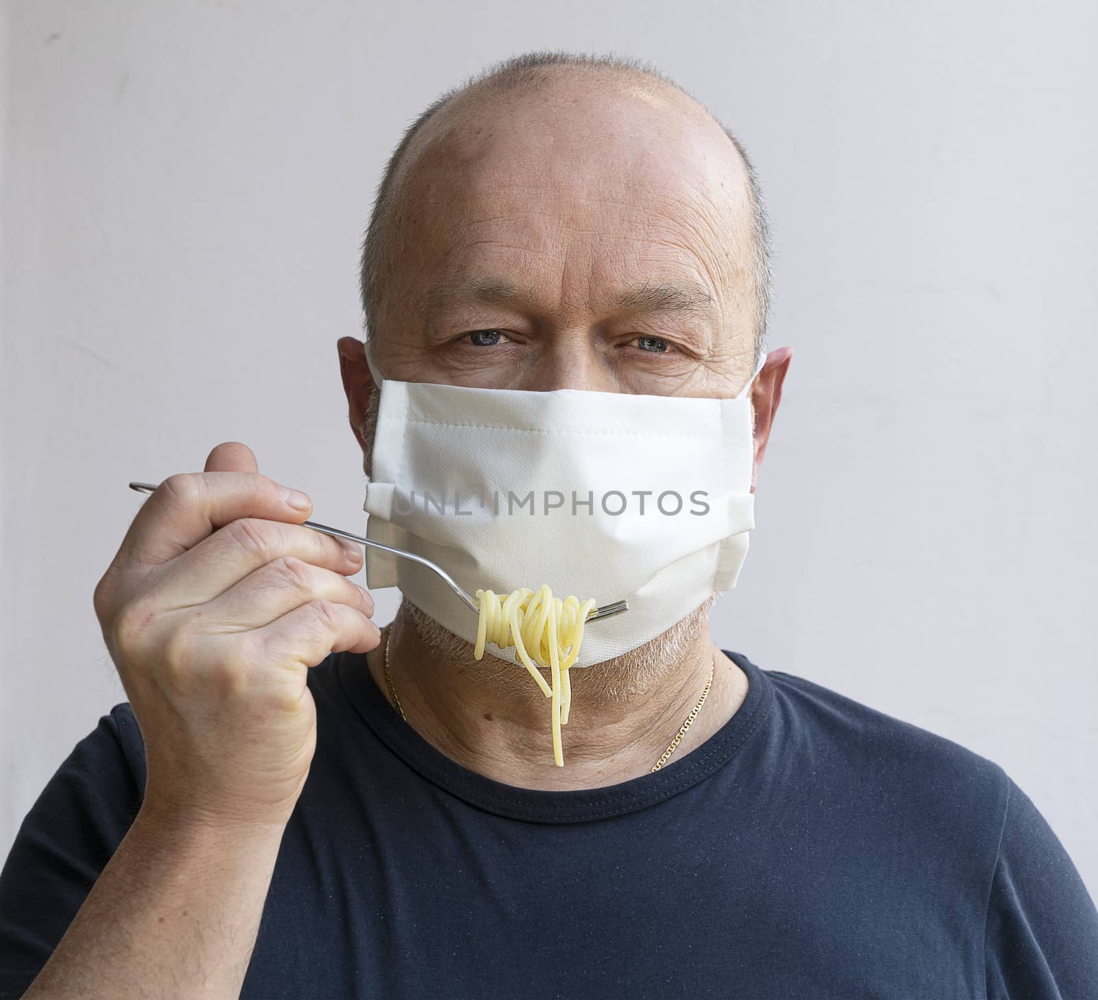 Eat pasta in the coronavirus period with a protective mask