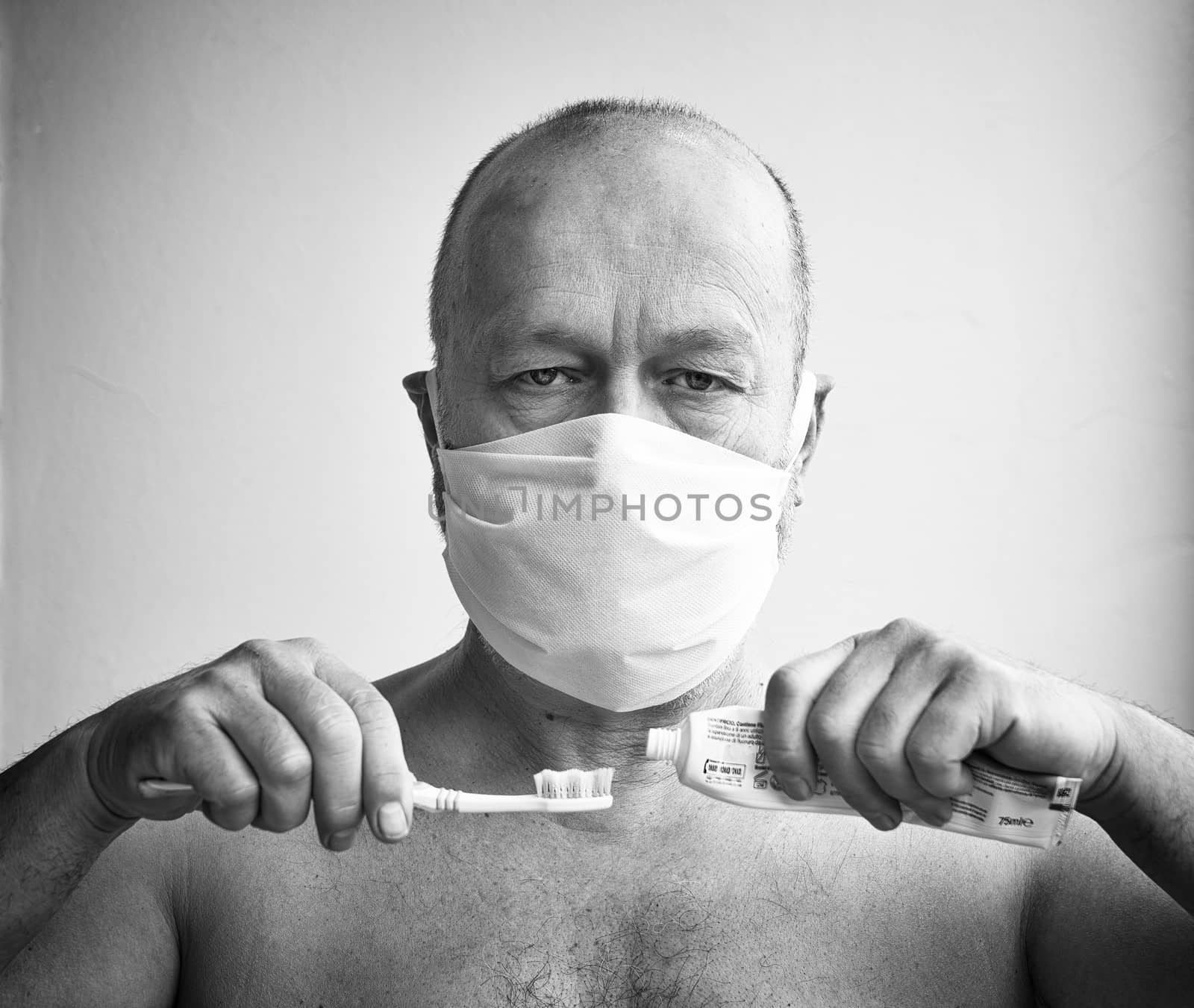 a man brushes his teeth with a protective mask during the coronavirus period