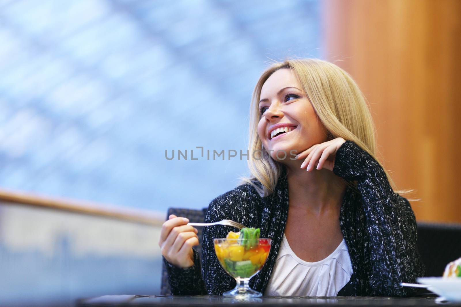 Happy smiling woman eat fruit dessert in cafe