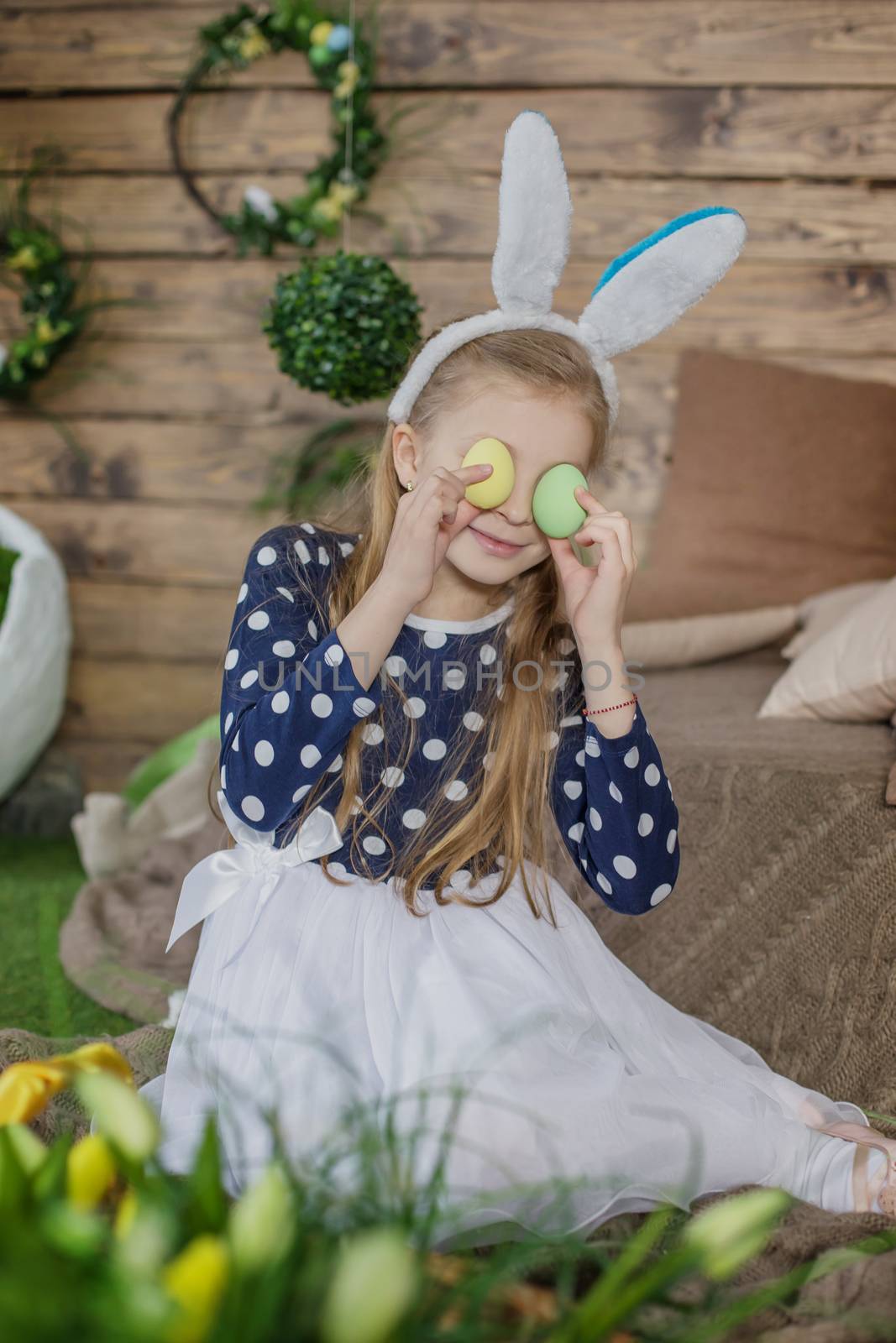 Portrait of girl having fun on Easter wearing bunny ears and hol by Angel_a