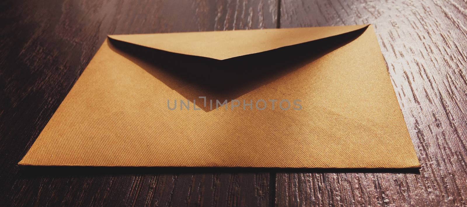 Golden vintage envelope on wooden background, newsletter and message concept