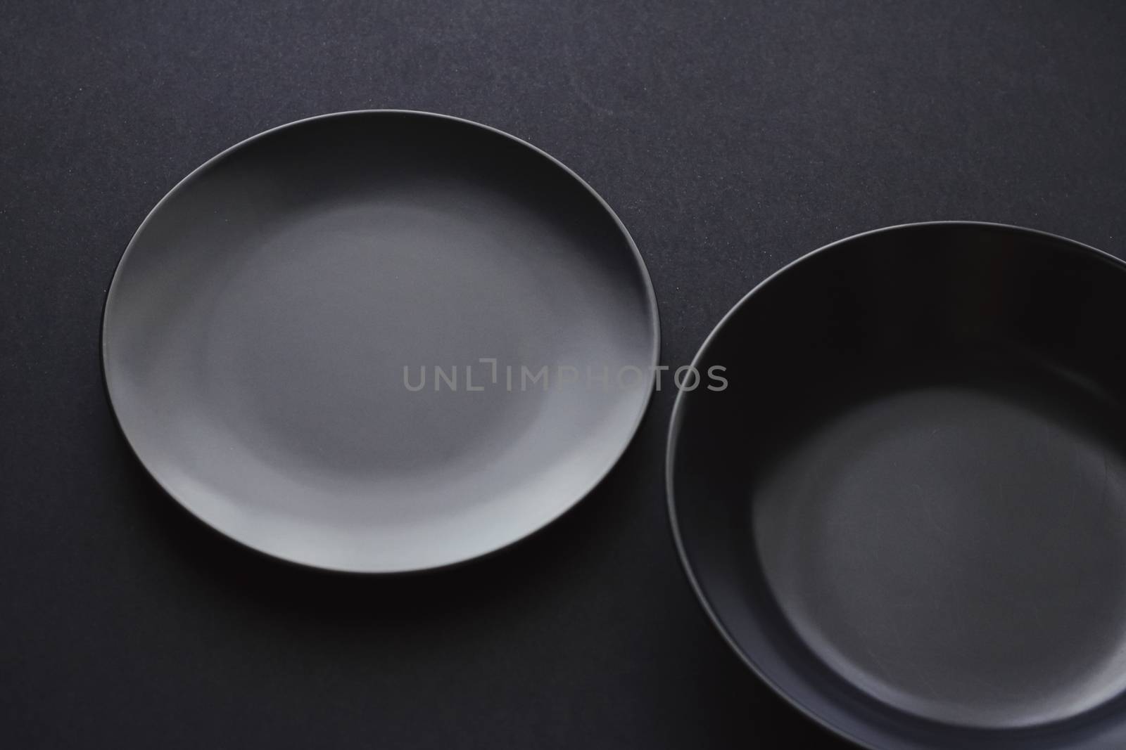 Empty plates on black background, premium dishware for holiday d by Anneleven