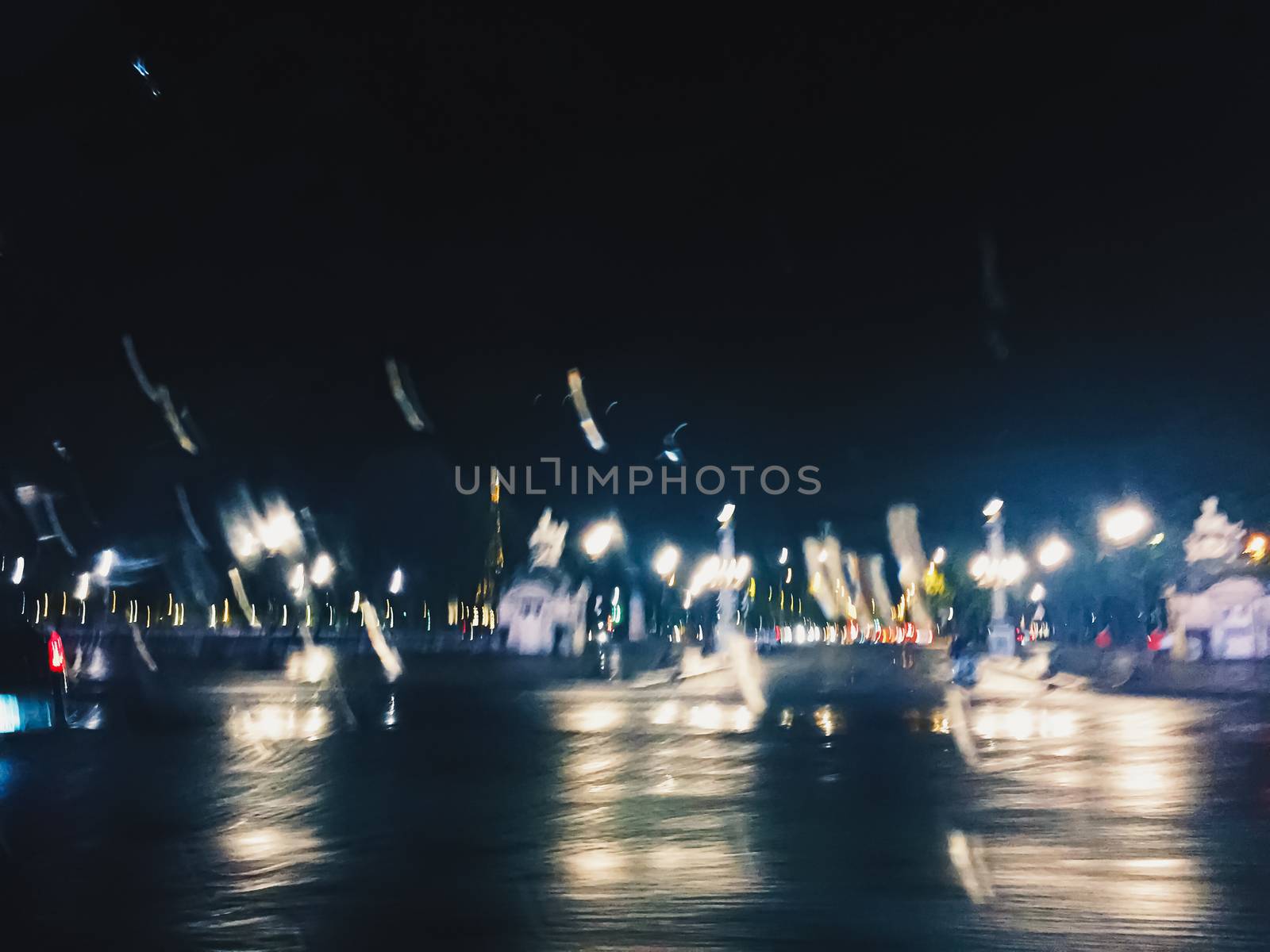 Abstract night city scene in Paris, France, motion blurred lights in the dark