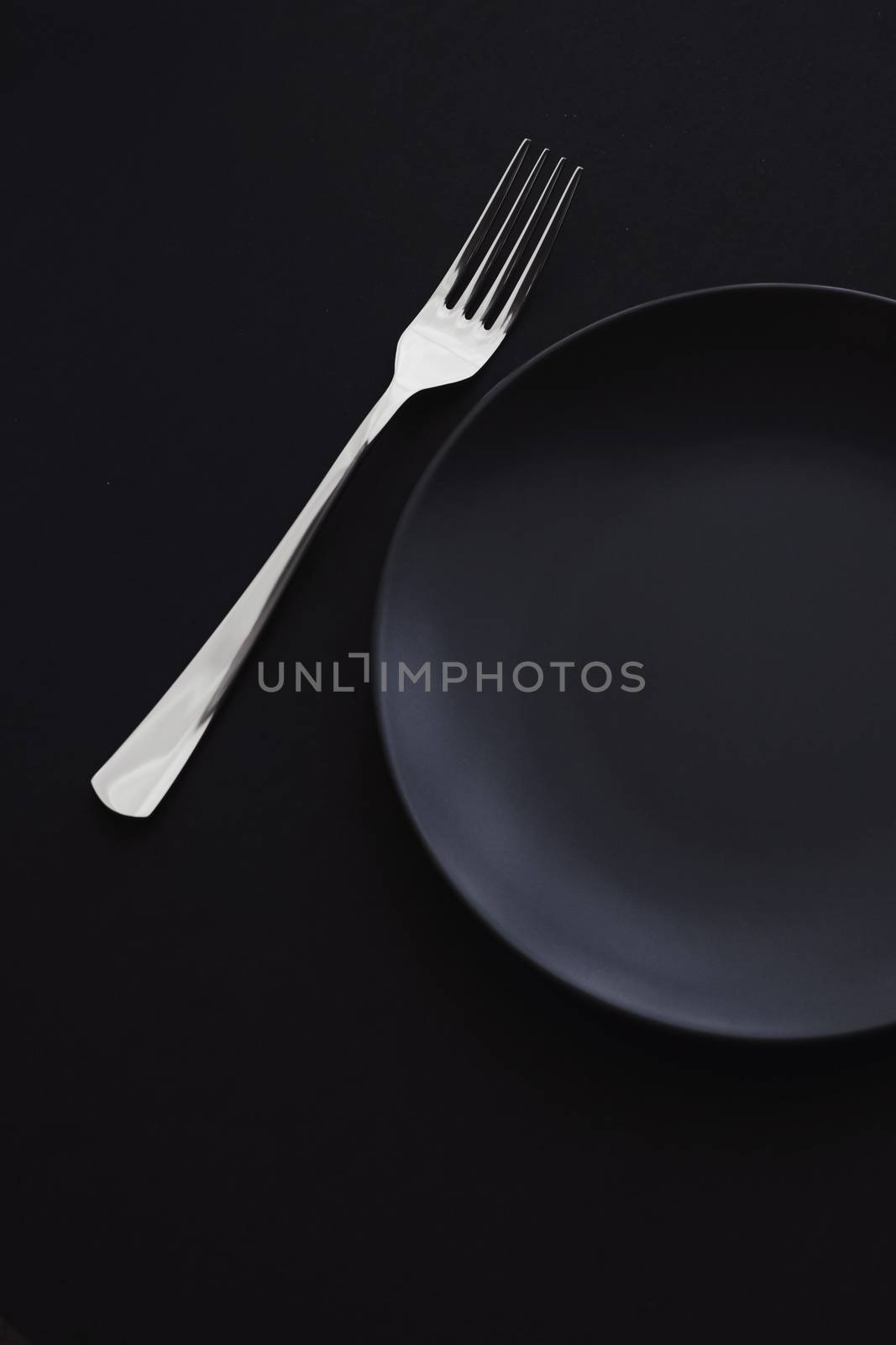 Empty plates and silverware on black background, premium tableware for holiday dinner, minimalistic design and diet concept