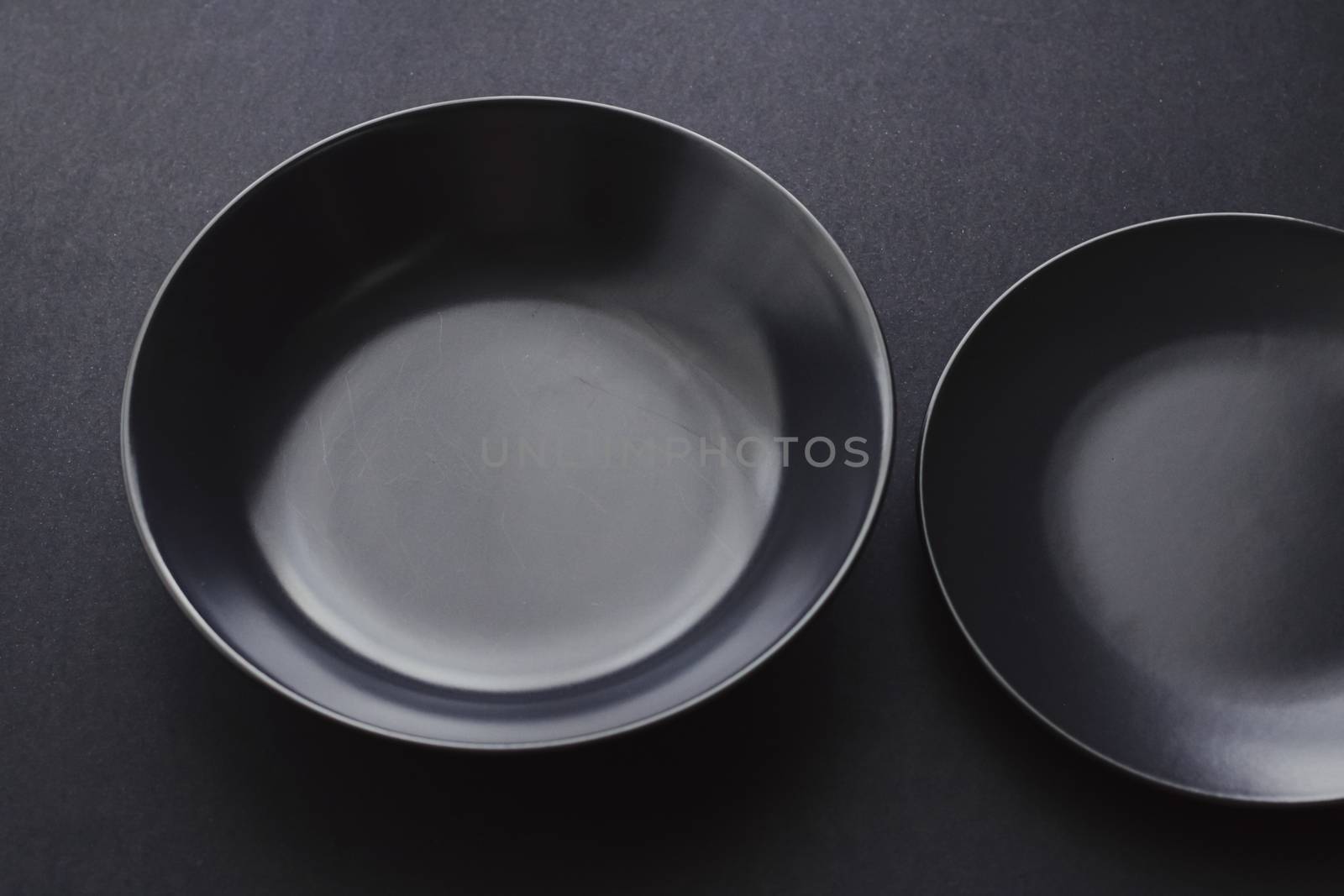 Empty plates on black background, premium dishware for holiday d by Anneleven