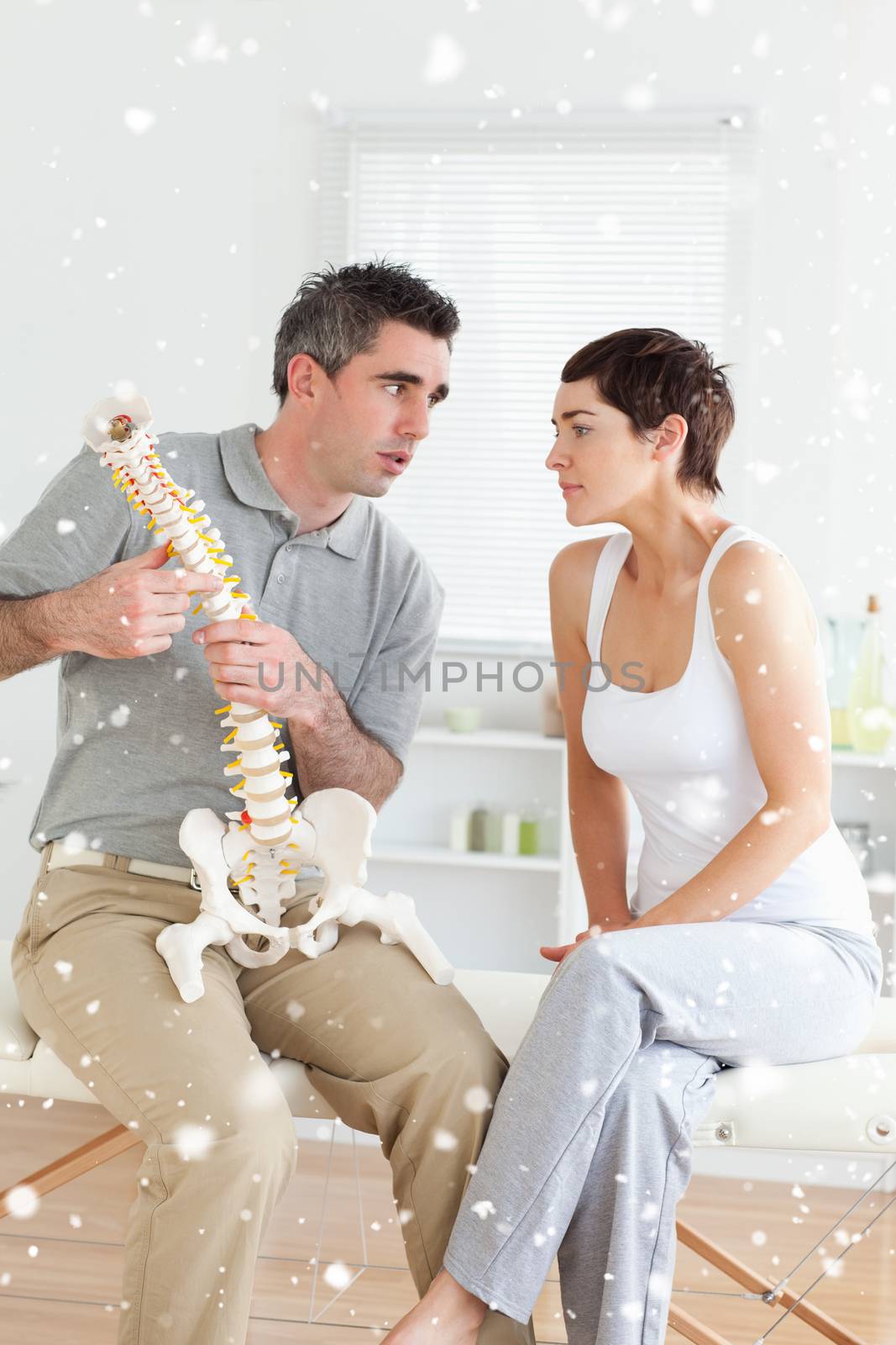 Composite image of Woman listening to her chiropractor in a snow falling