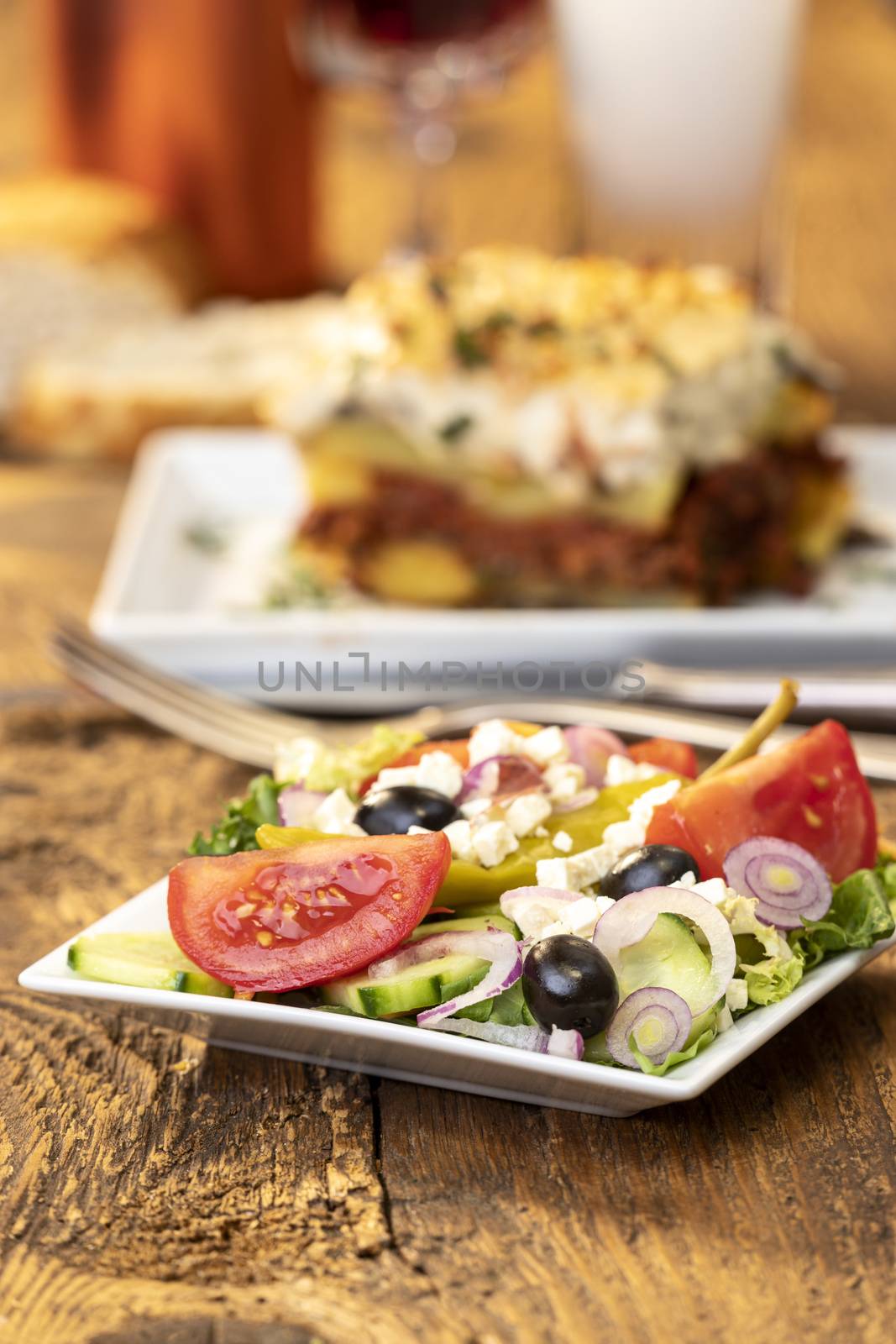 greek salad with moussaka on wood