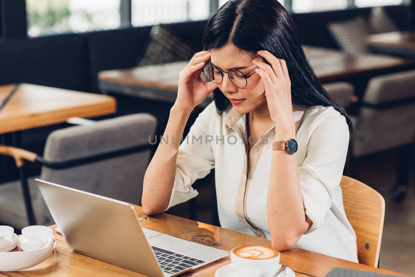 Lifestyle freelance working woman and laptop computer he headache unhappy on job in coffee cafe shop