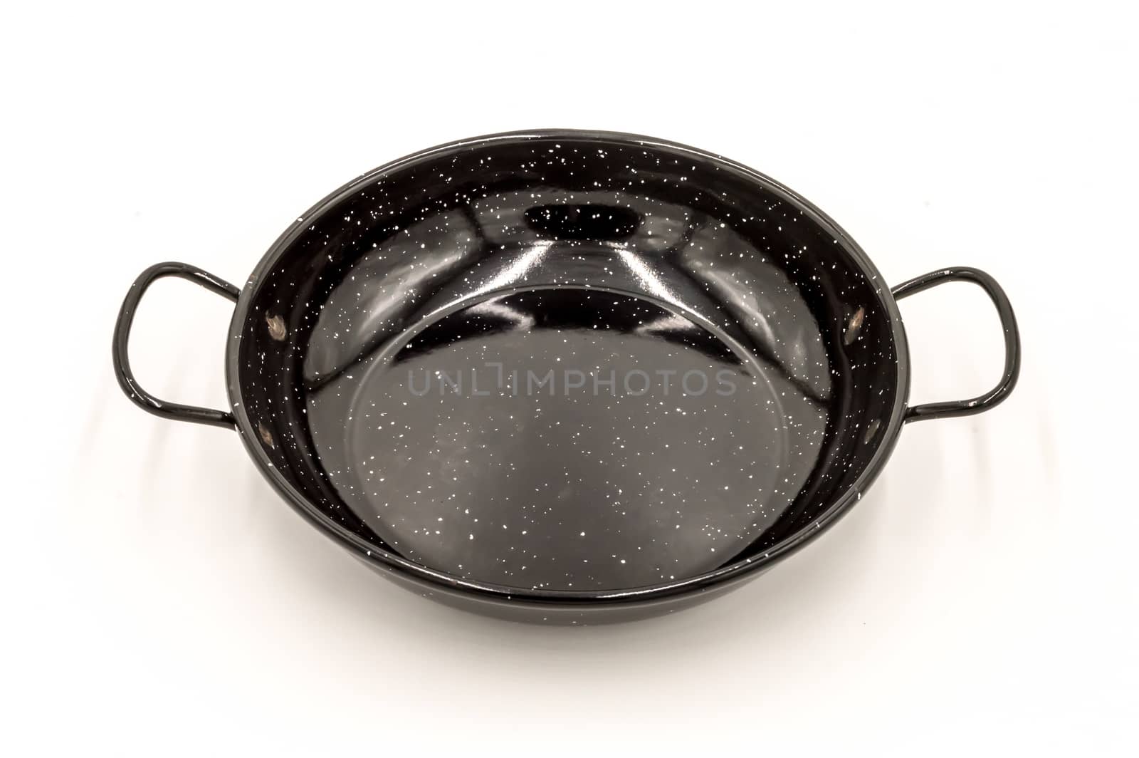 Empty paella pan on a white background, ready to cook