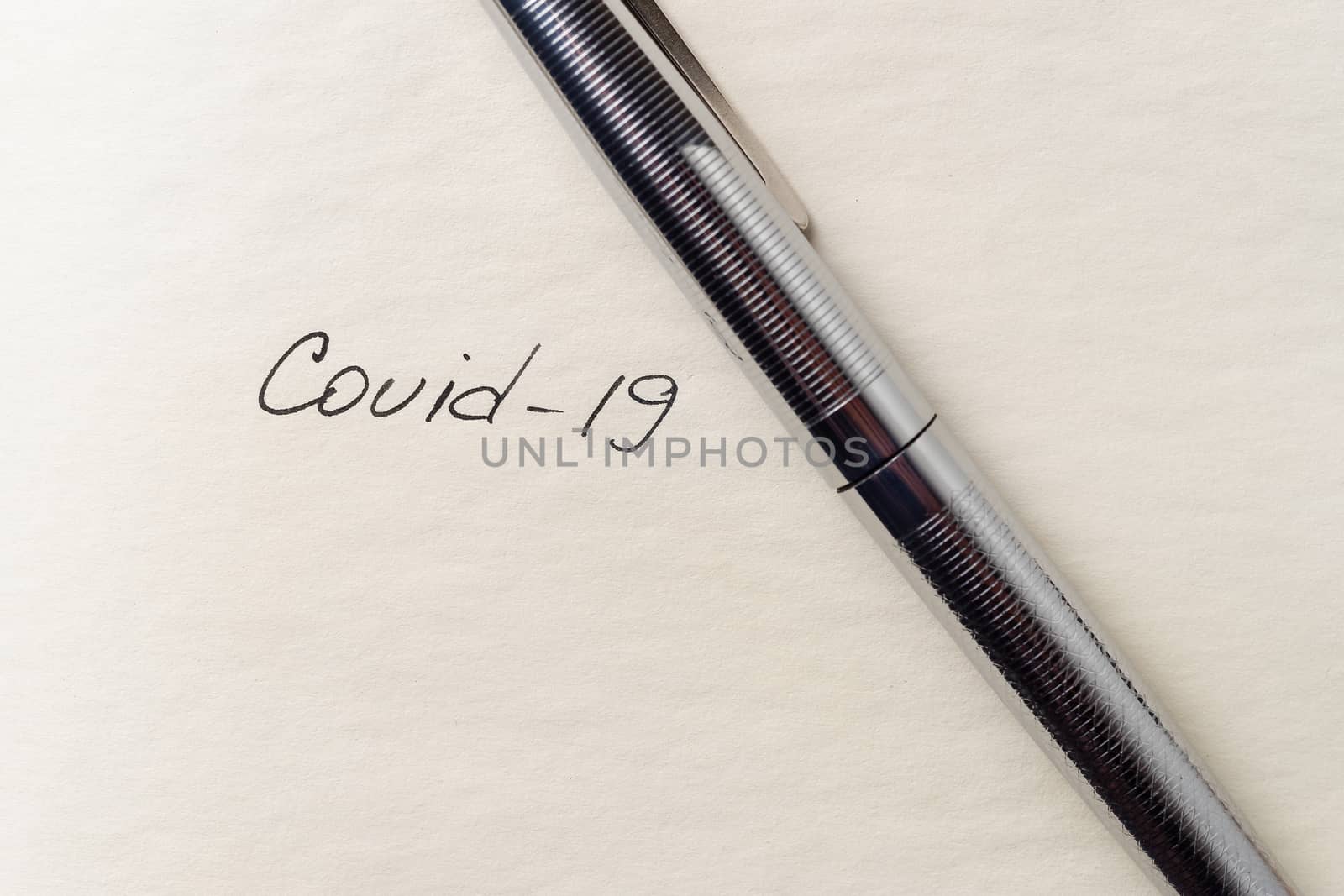 Covid-19 inscription on a blank empty sheet of paper in a notebo by alexsdriver