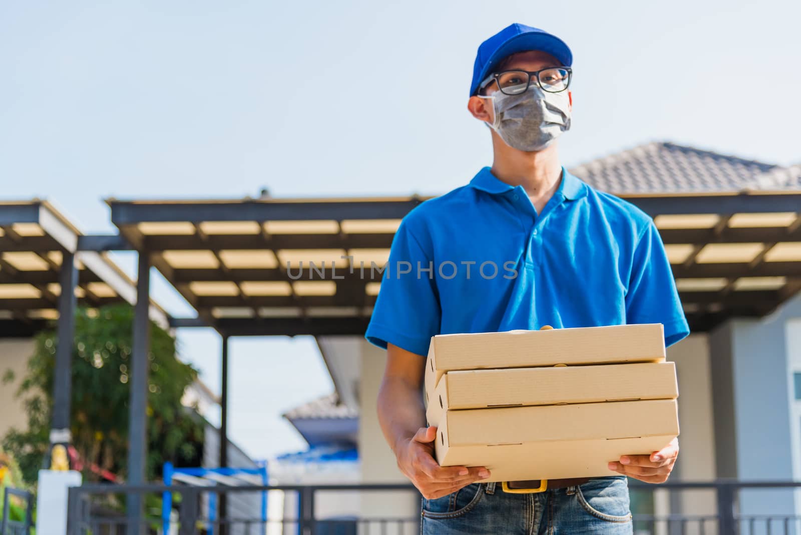 delivery man courier with food order is pizza boxes he protectiv by Sorapop