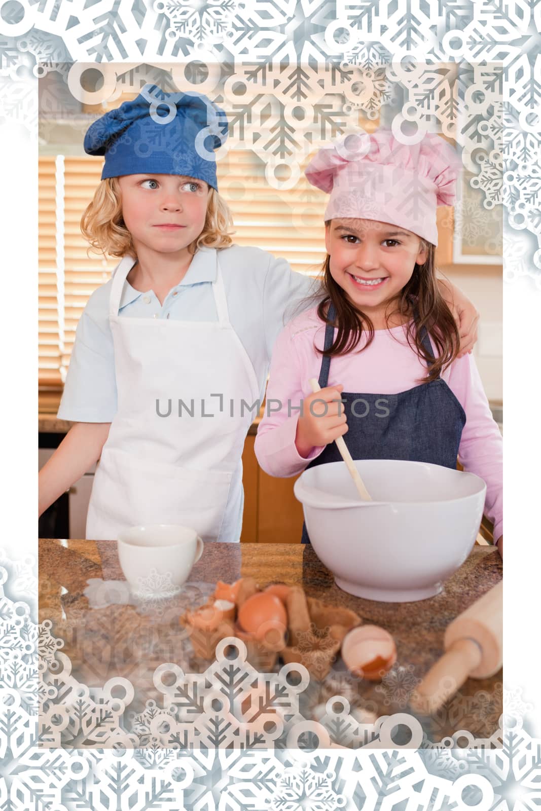 Portrait of siblings baking together against snowflakes on silver