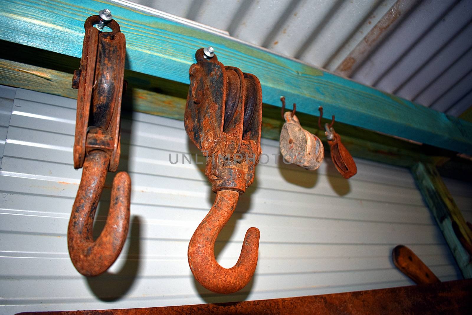 Rusty hooks and pulleys in a tin shed