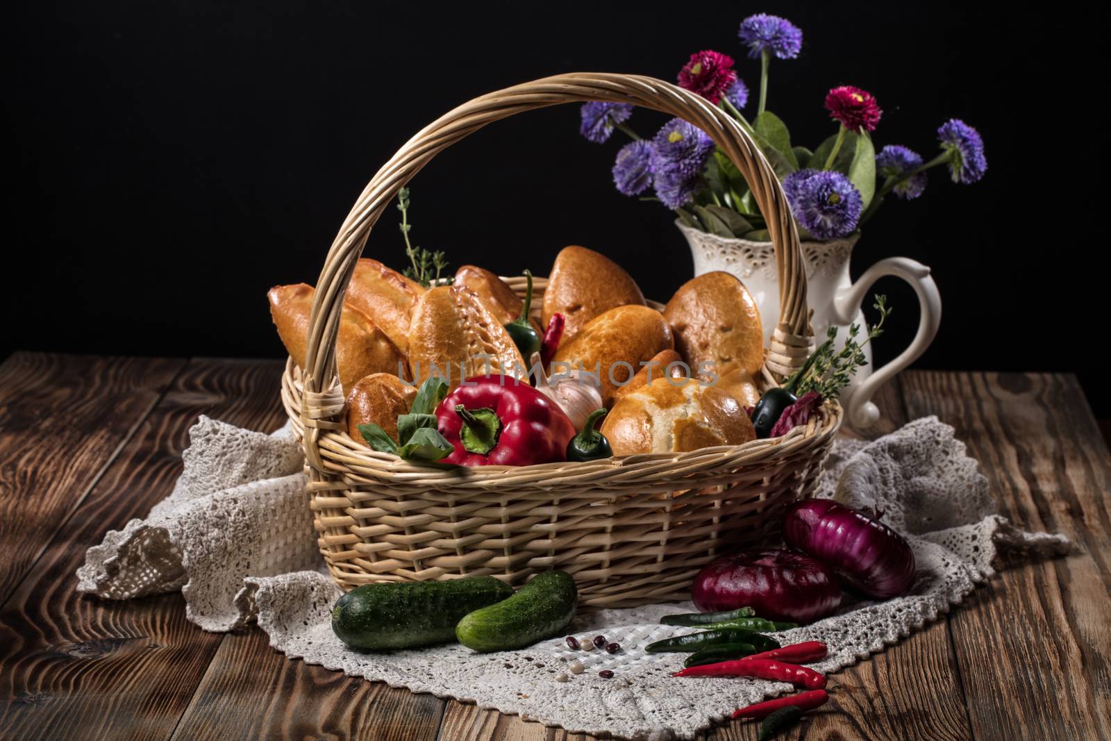 Pies with meat in the wicker basket on a black background