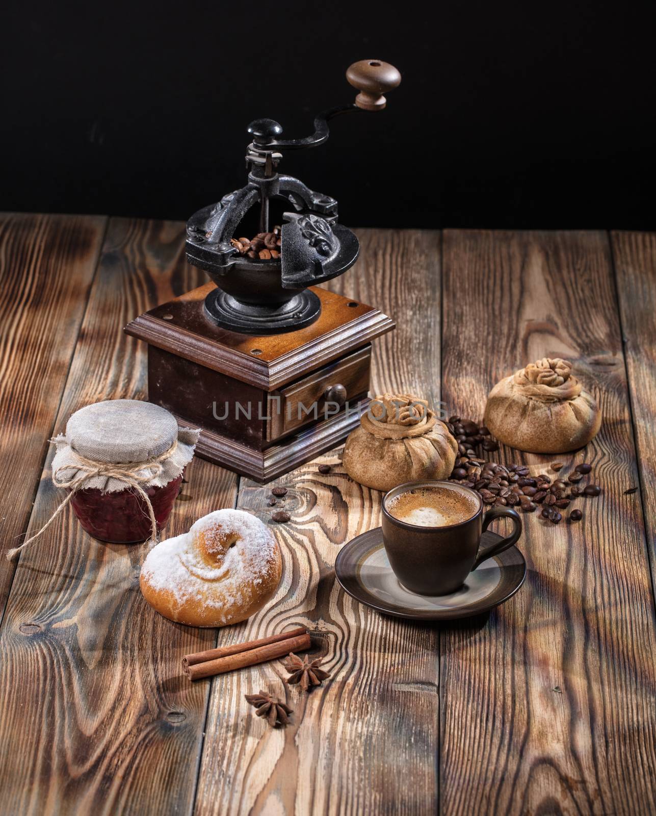 Coffee mill, cup of coffee and pies ona wooden desk