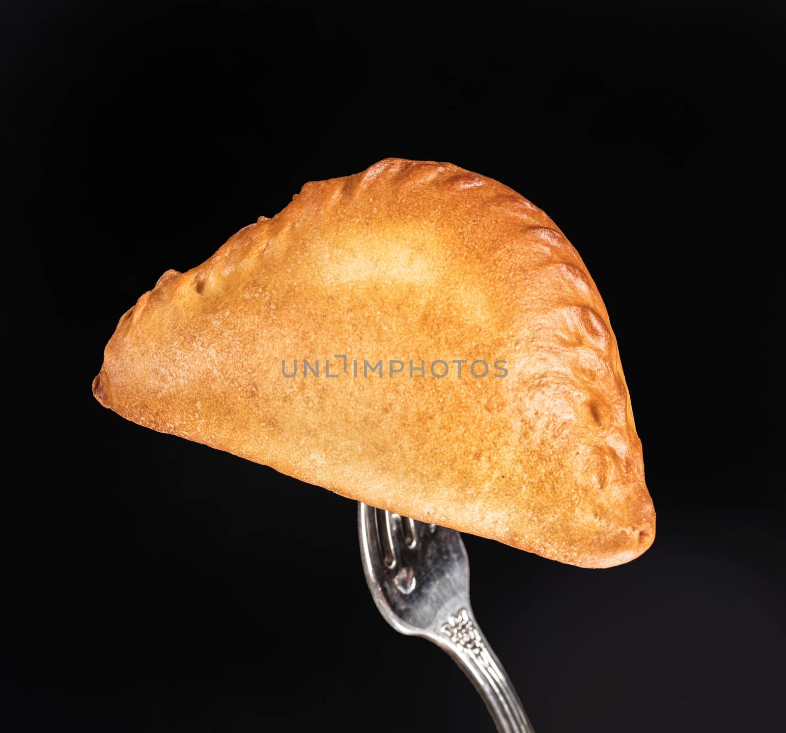 Pie on a fork on a black studio background