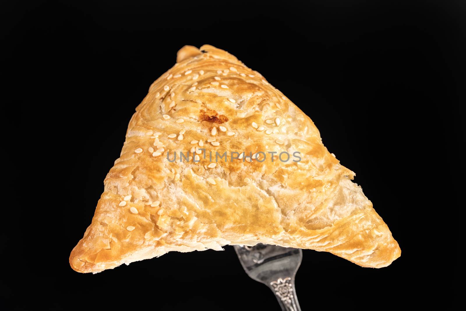 Pie on a fork on a black studio background