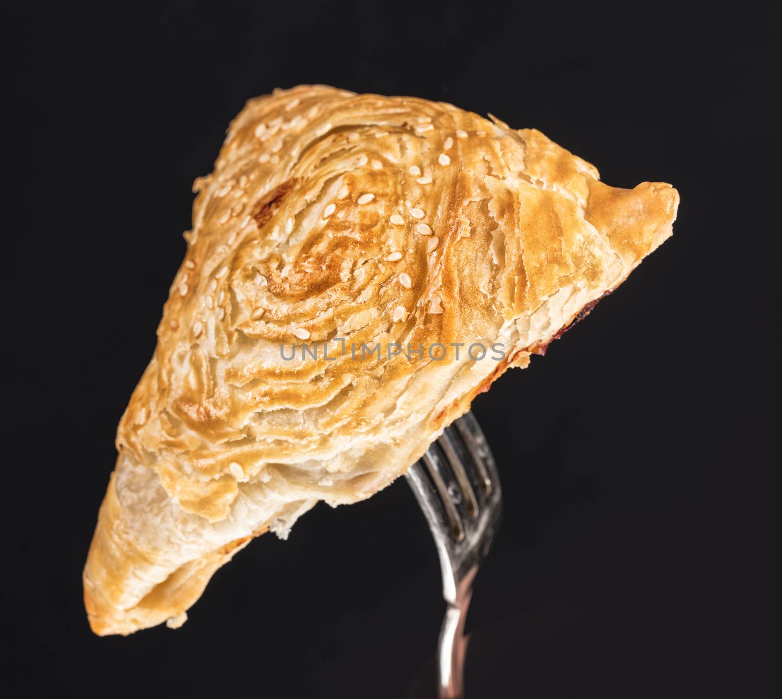 Pie on a fork on a black studio background