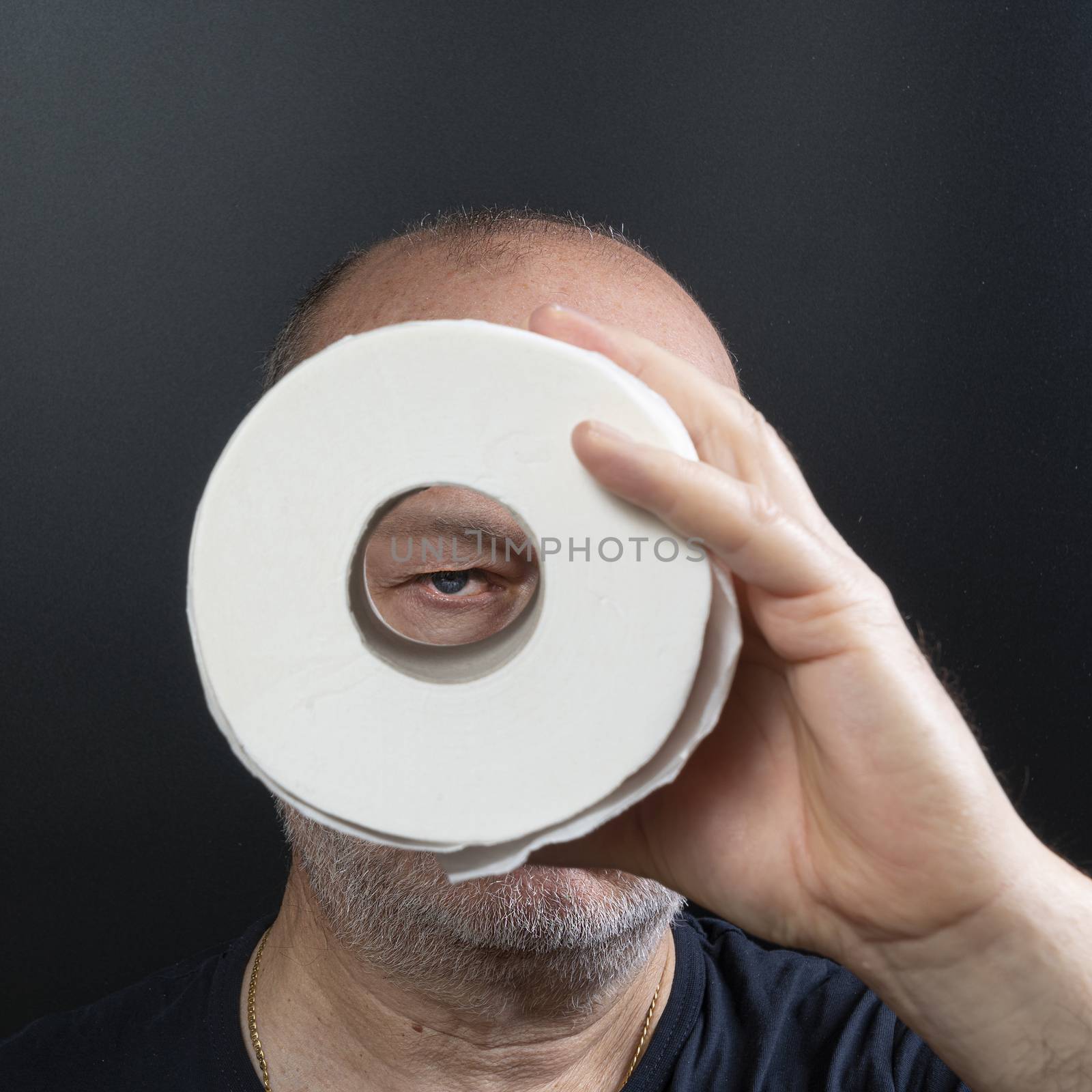 a man looks through a roll of toilet paper