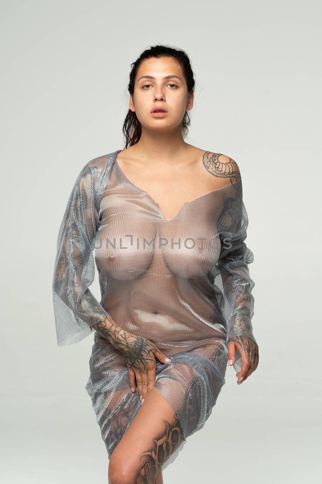 young beautiful girl posing in a transparent dress in the studio