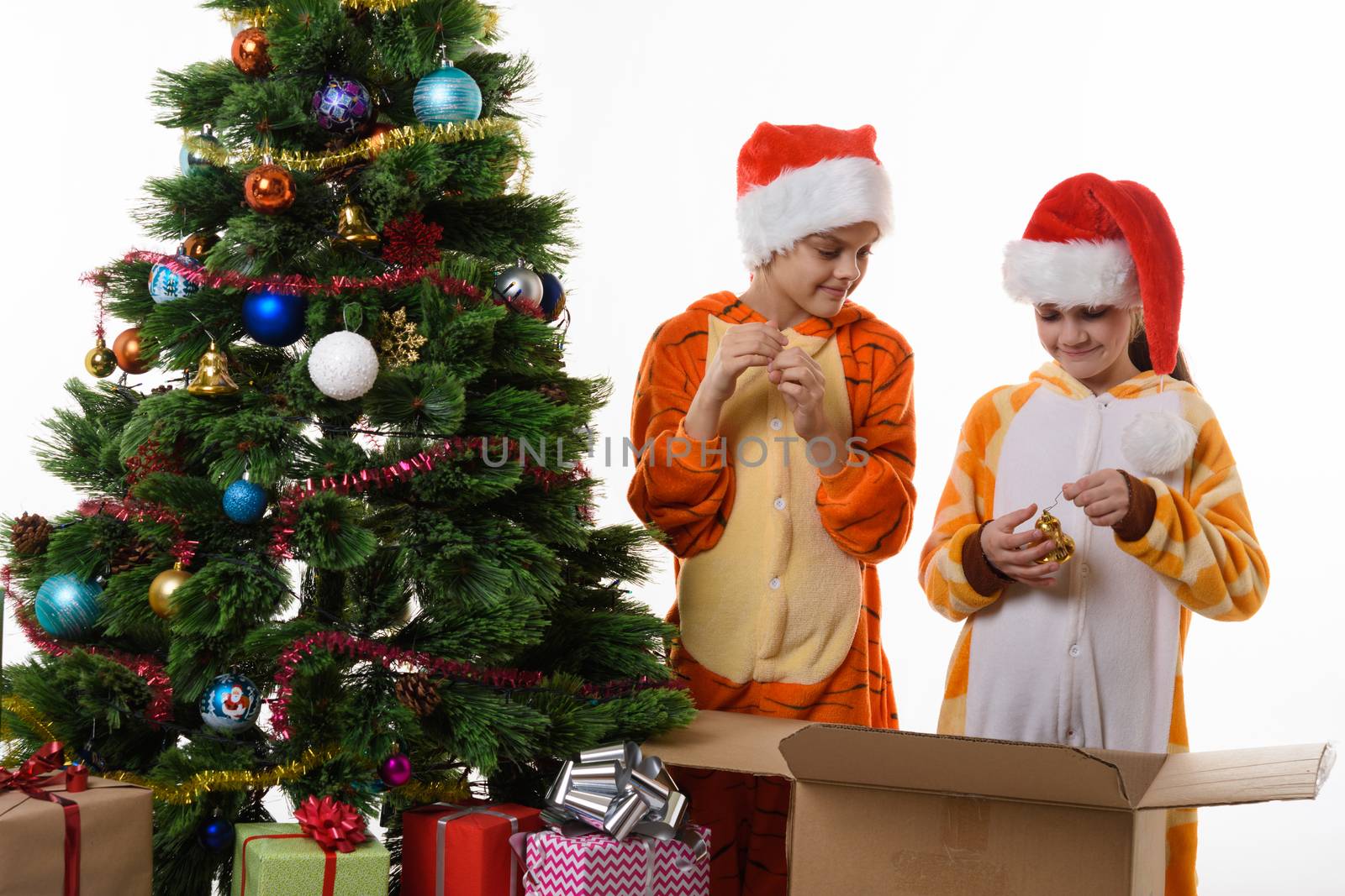 Girls examine New Year's toys decorating the Christmas tree