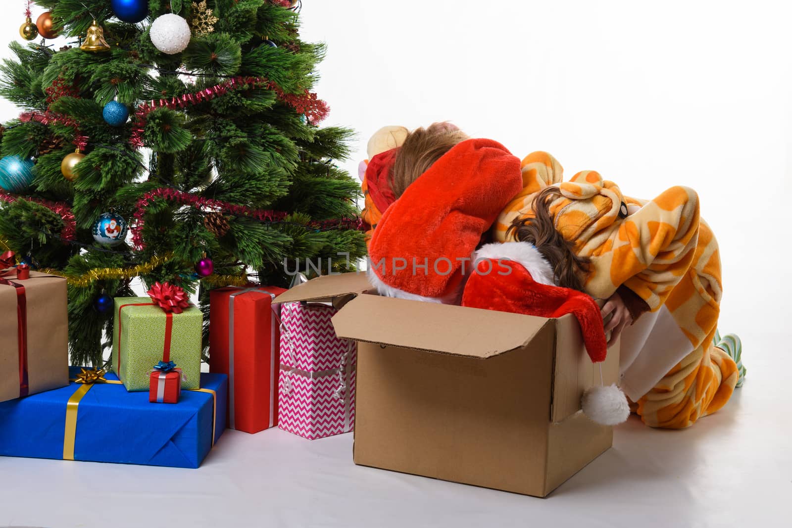 Two girls crawled headlong into a box with New Year's toys