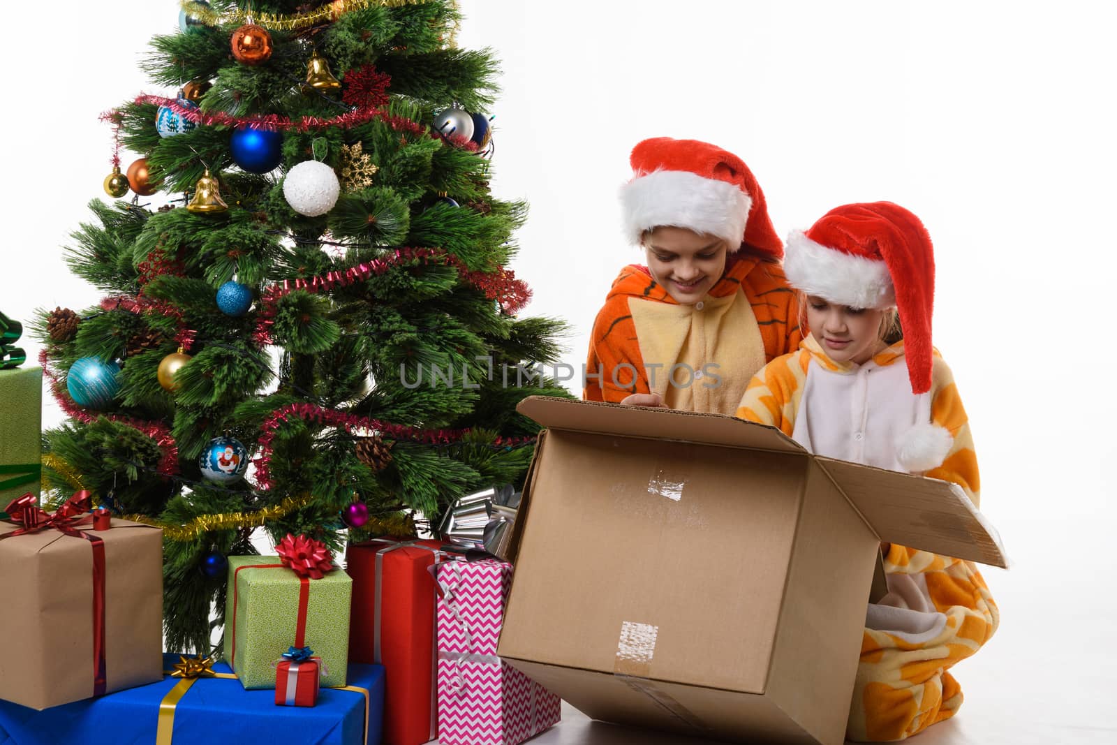 Two girls look in a box with New Year's toys