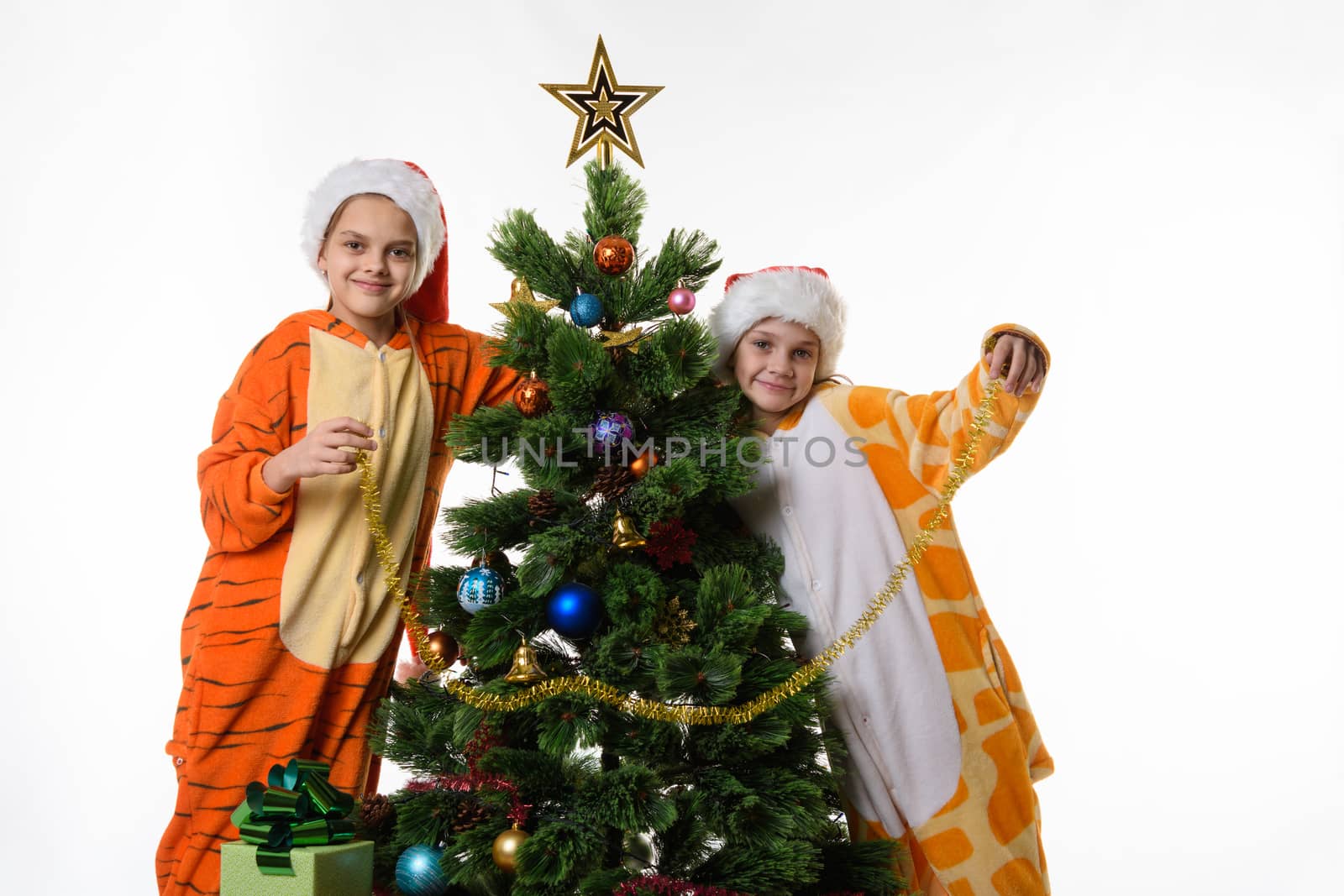 Portrait of two girls in pajamas near the Christmas tree