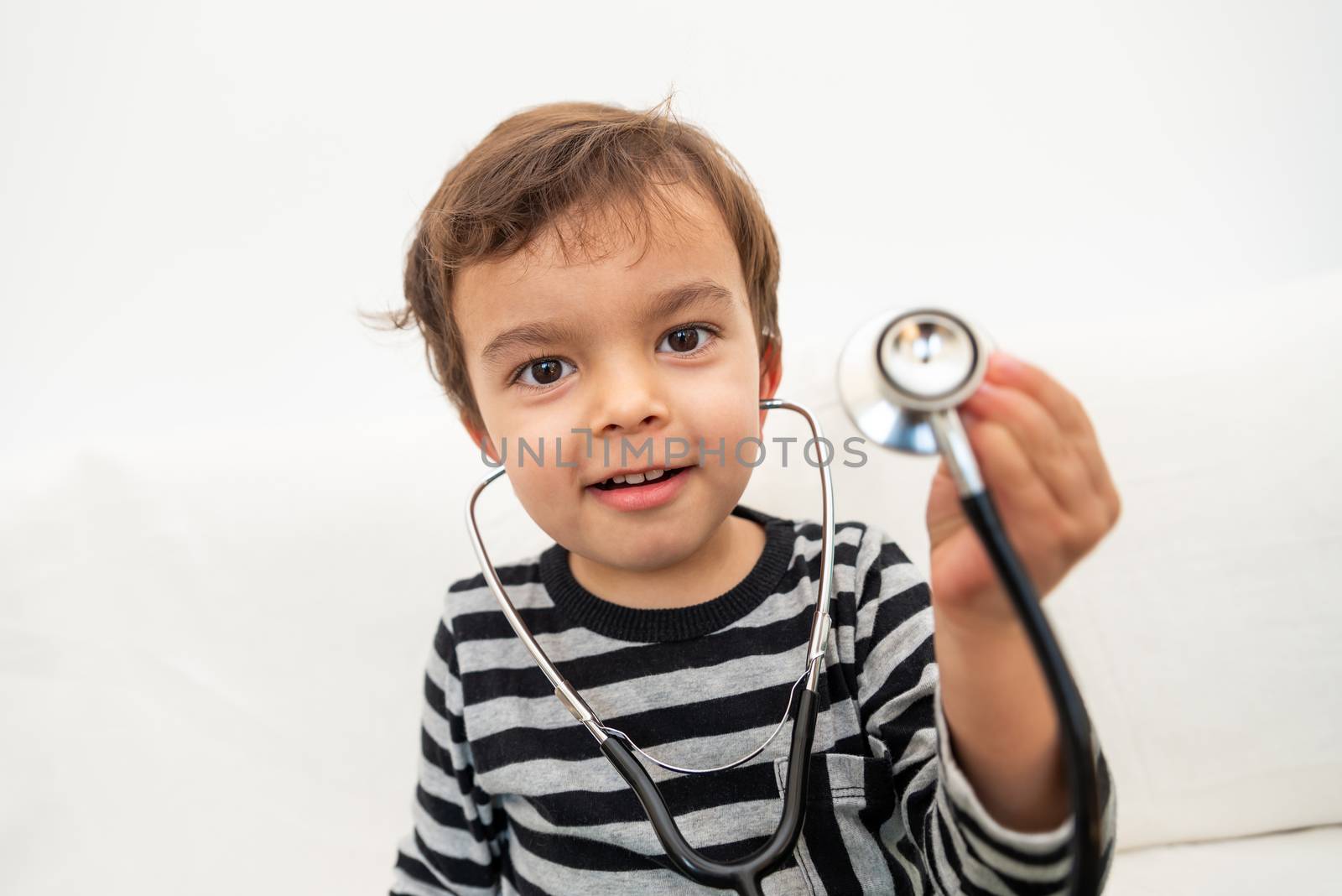 Toddler playing with stethoscope by dutourdumonde