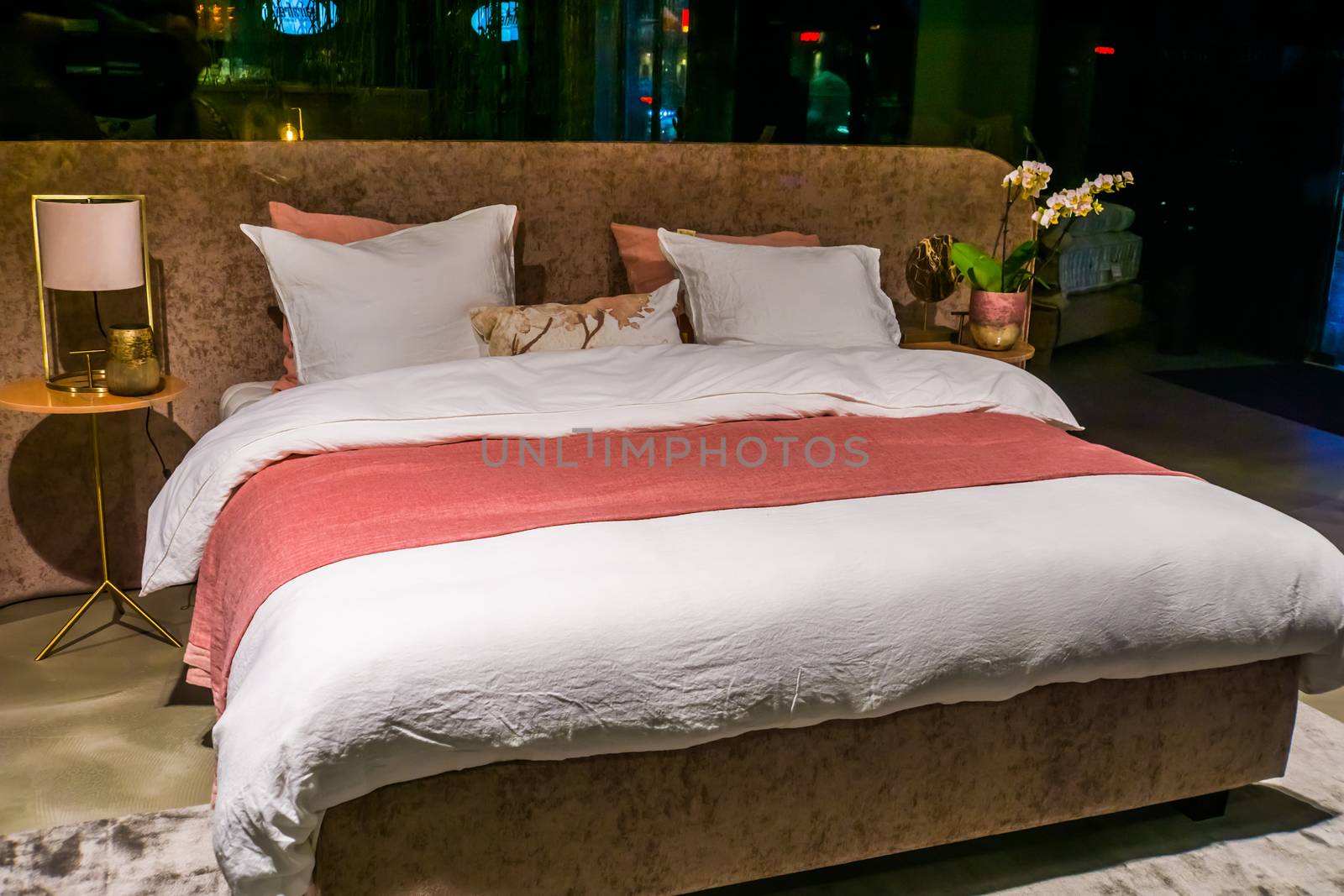 Modern double bed, luxurious bedroom interior, made bed with sheets and pillows