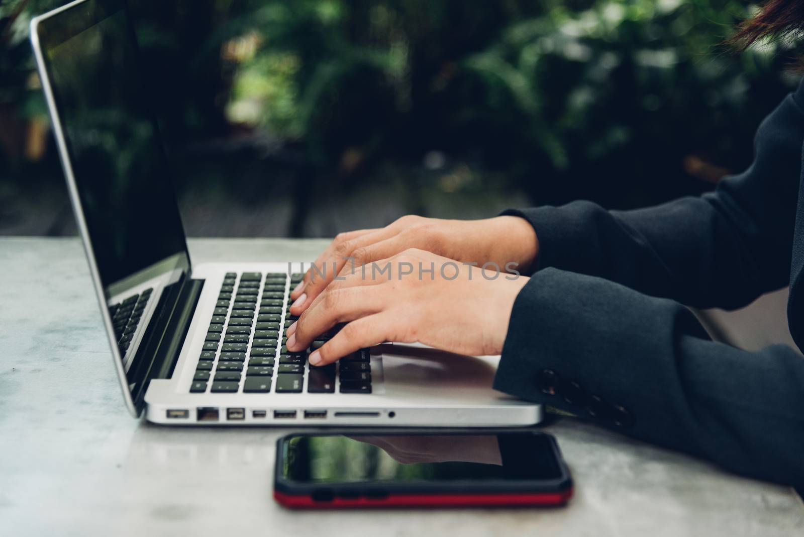 Business woman using his computer laptop on The desk is surrounded by nature