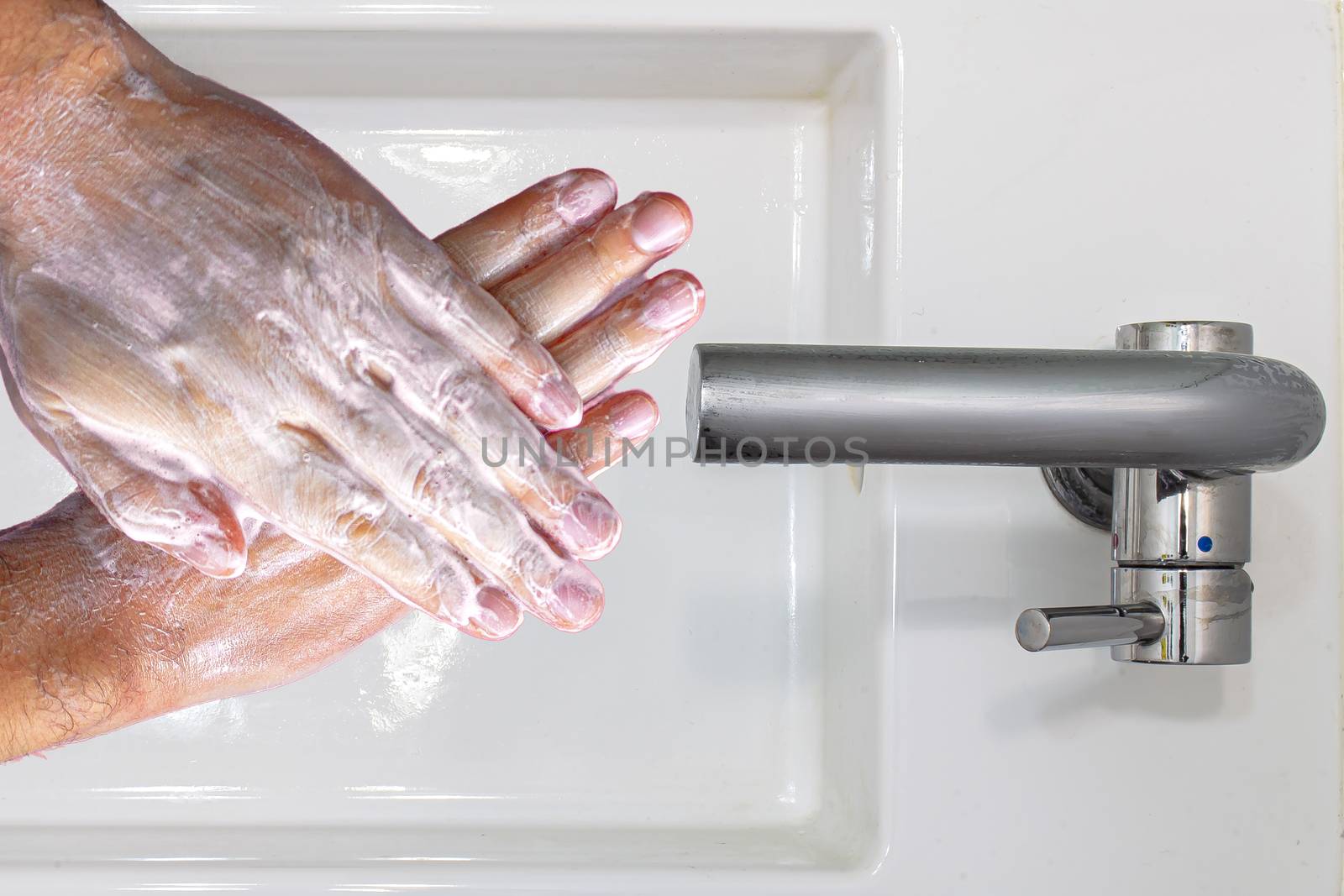 Top view of a person washing hands with soap on a wash basin by oasisamuel