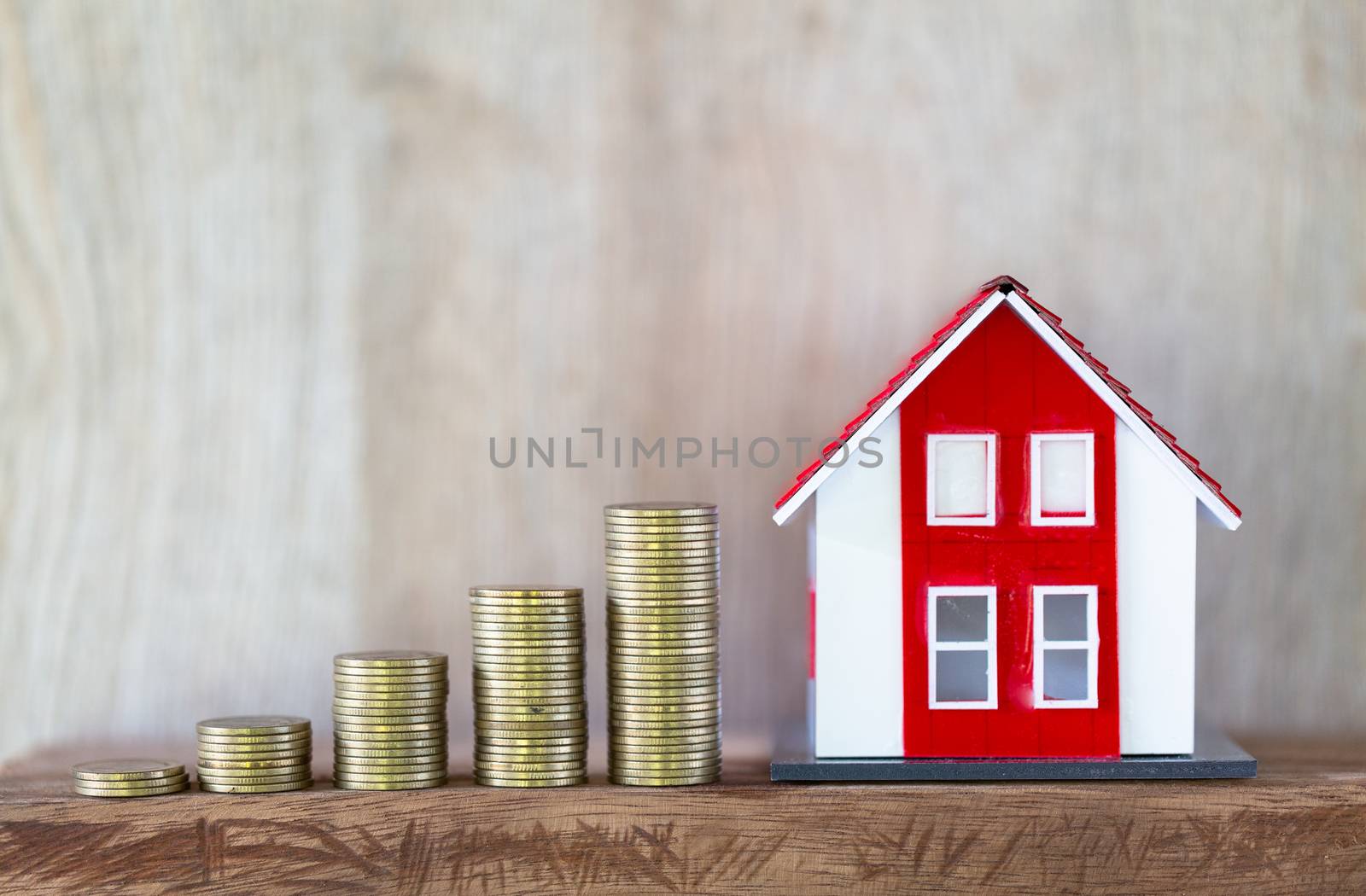Red roof house model. Coins that are stacked from low to high. Financial and banking concepts Preparing for home purchase and real estate economic growth. Home mortgage finance.