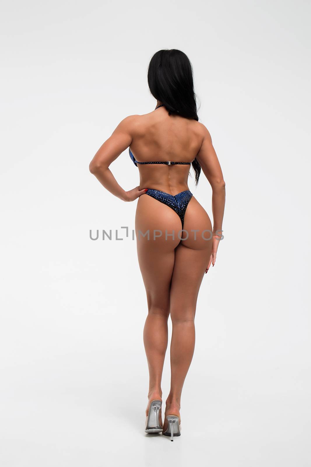 Back view of crop sexual woman with perfect body in blue bikini isolated on white background
