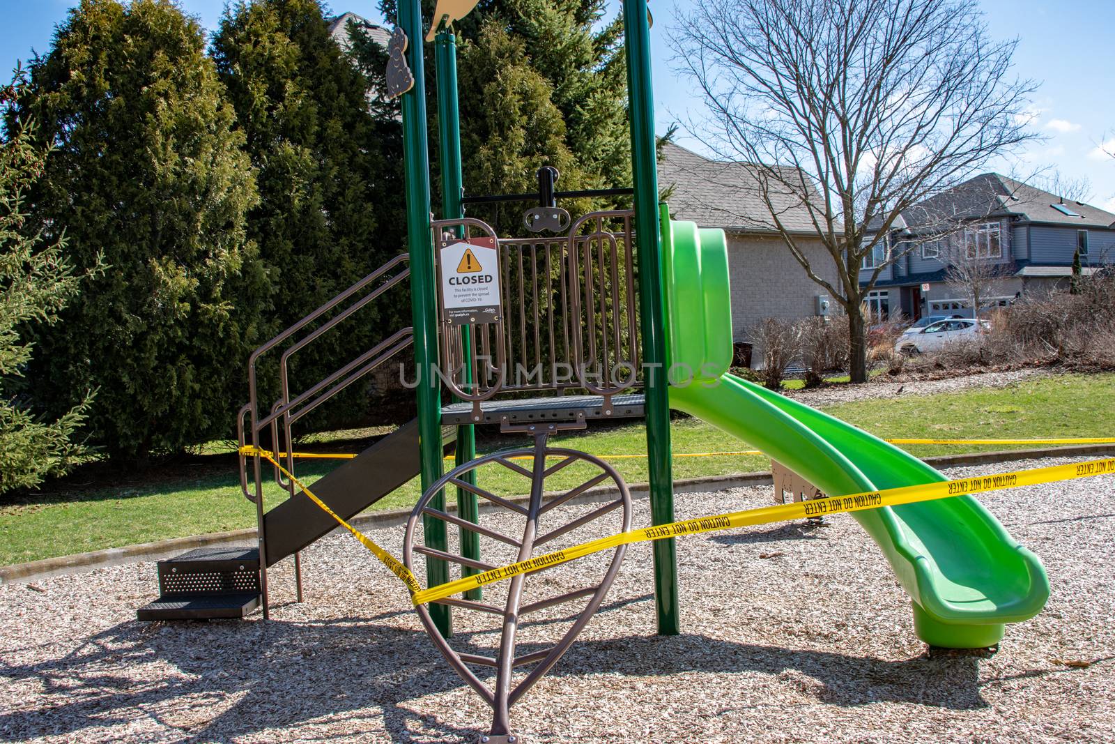 The slide on the playground is surrounded by a yellow ribbon and a warning plate has been installed on closing for the period of quarantine