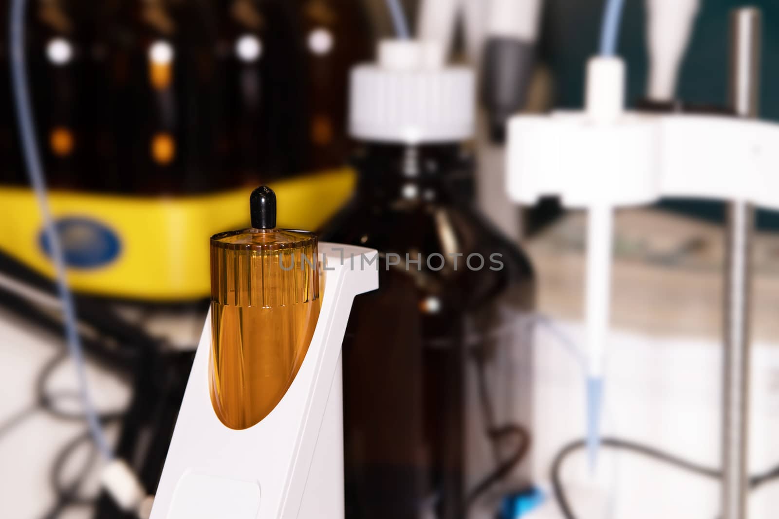 Close-up of a laboratory glass flask with a yellow liquid on a laboratory table for experiments. The concept of scientific research and development.