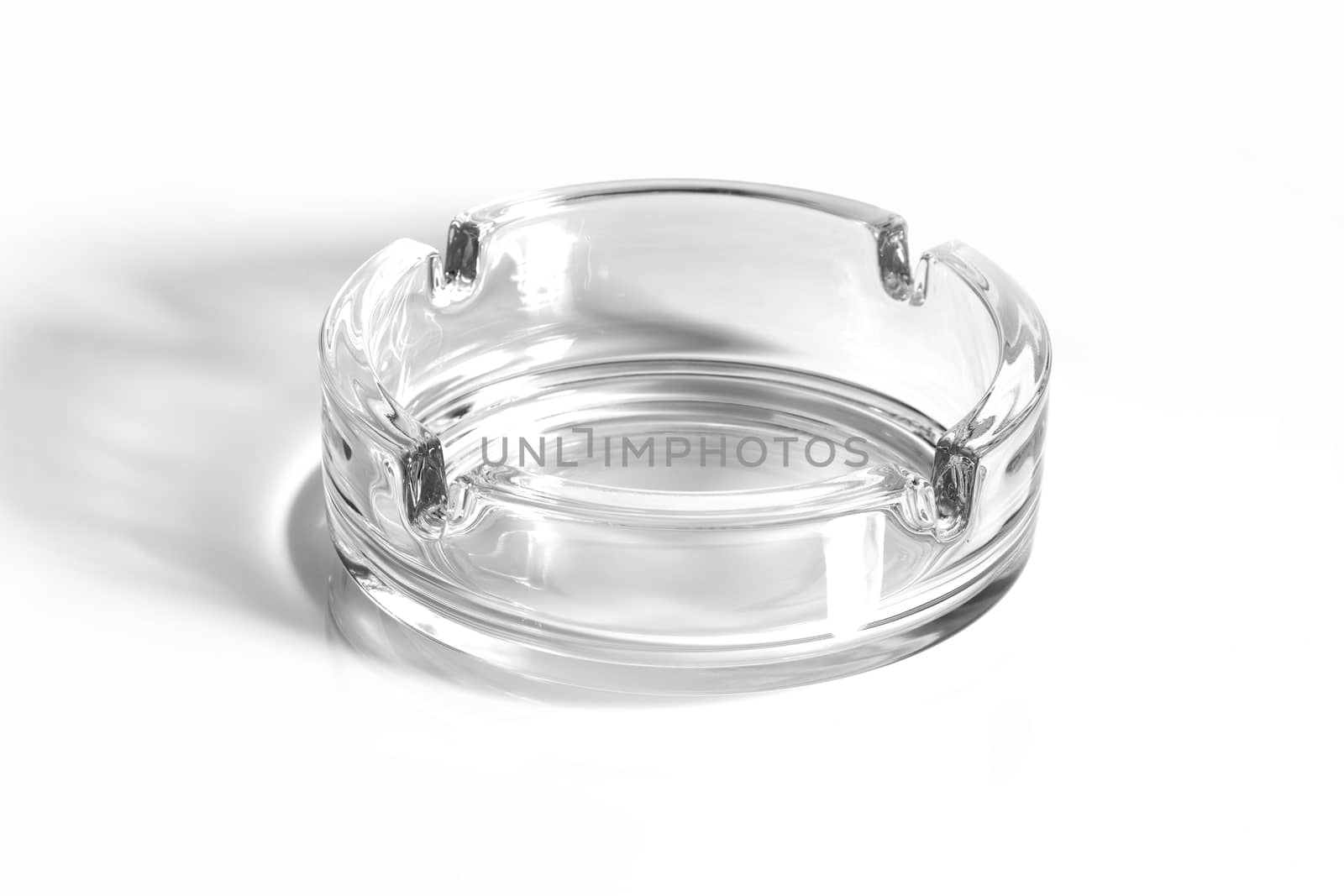 A glass ash tray on white background with shadow