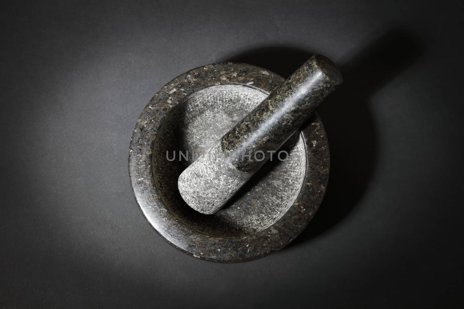 A top view of mortar and pestle on dark surface