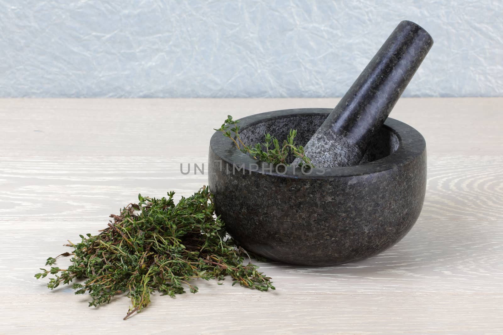 thyme on wooden kitchen surface and mortar and pestle by VivacityImages