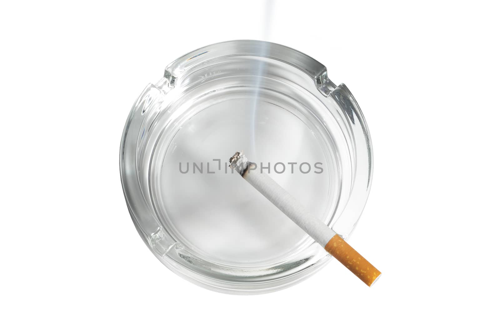 Top view of a cigarette lit in glass ashtray on white by VivacityImages
