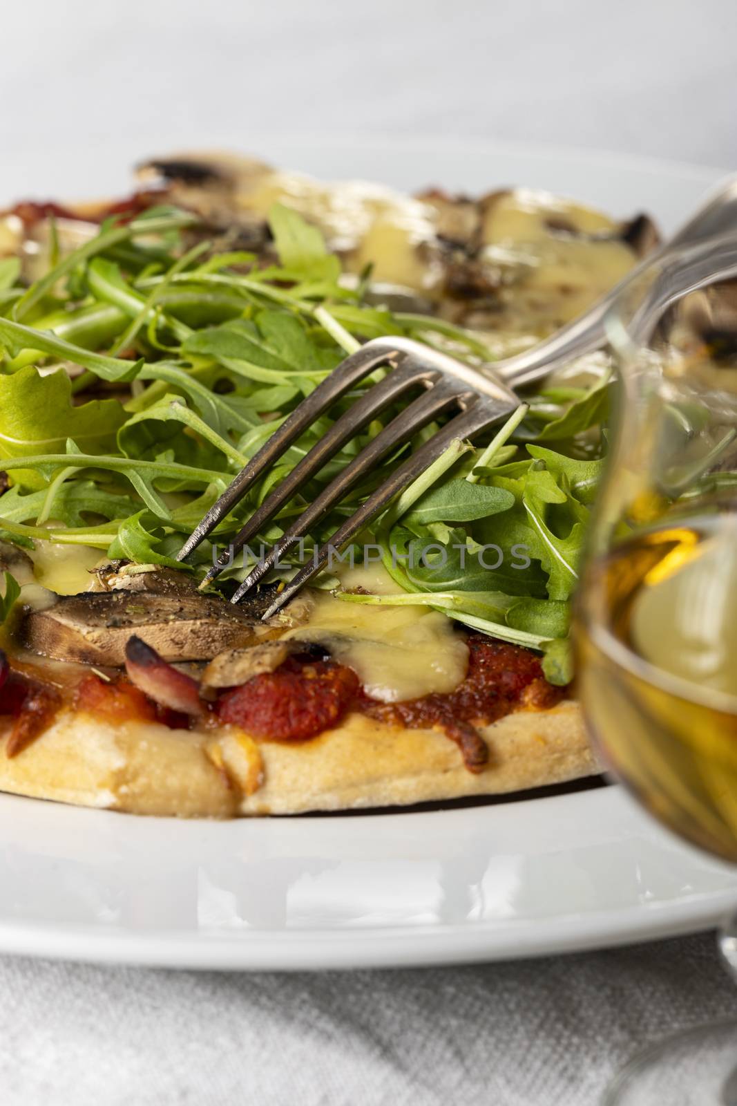 pizza on a plate with arugula by bernjuer